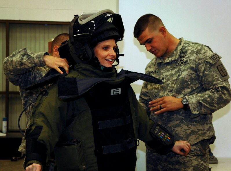 Daniela Peele, a member of the Greater Fort Walton Beach Military Affairs Committee, tries on a bomb suit while on a tour of Naval School Explosive Ordnance Disposal Feb. 22. Peele, along with more than 30 MAC members, received a tour of the school to familiarize themselves with the school and its mission. NAVSCOLEOD, located on Eglin Air Force Base, Fla. provides high-risk, specialized, basic and advanced EOD training to more than 2,100 U.S. and partner nation military and selected U.S. government personnel each year. (U.S. Navy photo/Ensign Elizabeth Allen)