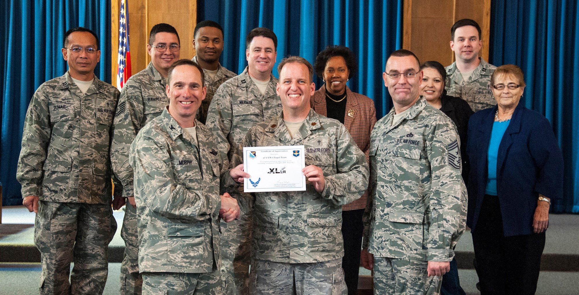 The 47th Flying Training Wing’s chapel team, poses with Col. Tom Murphy, 47th Flying Training Wing commander and Chief Master Sgt. Garry Berry, 47th FTW command chief, after being presented the XLer of the week award at Laughlin Air Force Base, Texas, Feb. 27, 2013. The XLer is a weekly award chosen by wing leadership and given to those who consistently make outstanding contributions to Laughlin and their unit. (U.S. Air Force photo/Senior Airman Nathan Maysonet) 