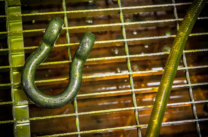 A horseshoe shaped collar is sprayed with dye March 8, 2013, at Joint Base Charleston – Air Base, S.C. After the dye dries, the part is placed under ultraviolet lights to reveal cracks or flaws in the metal. The inspection process can take up to an hour for each part, and also includes three separate chemical baths and a drying machine. (U.S. Air Force photo/Senior Airman Dennis Sloan)