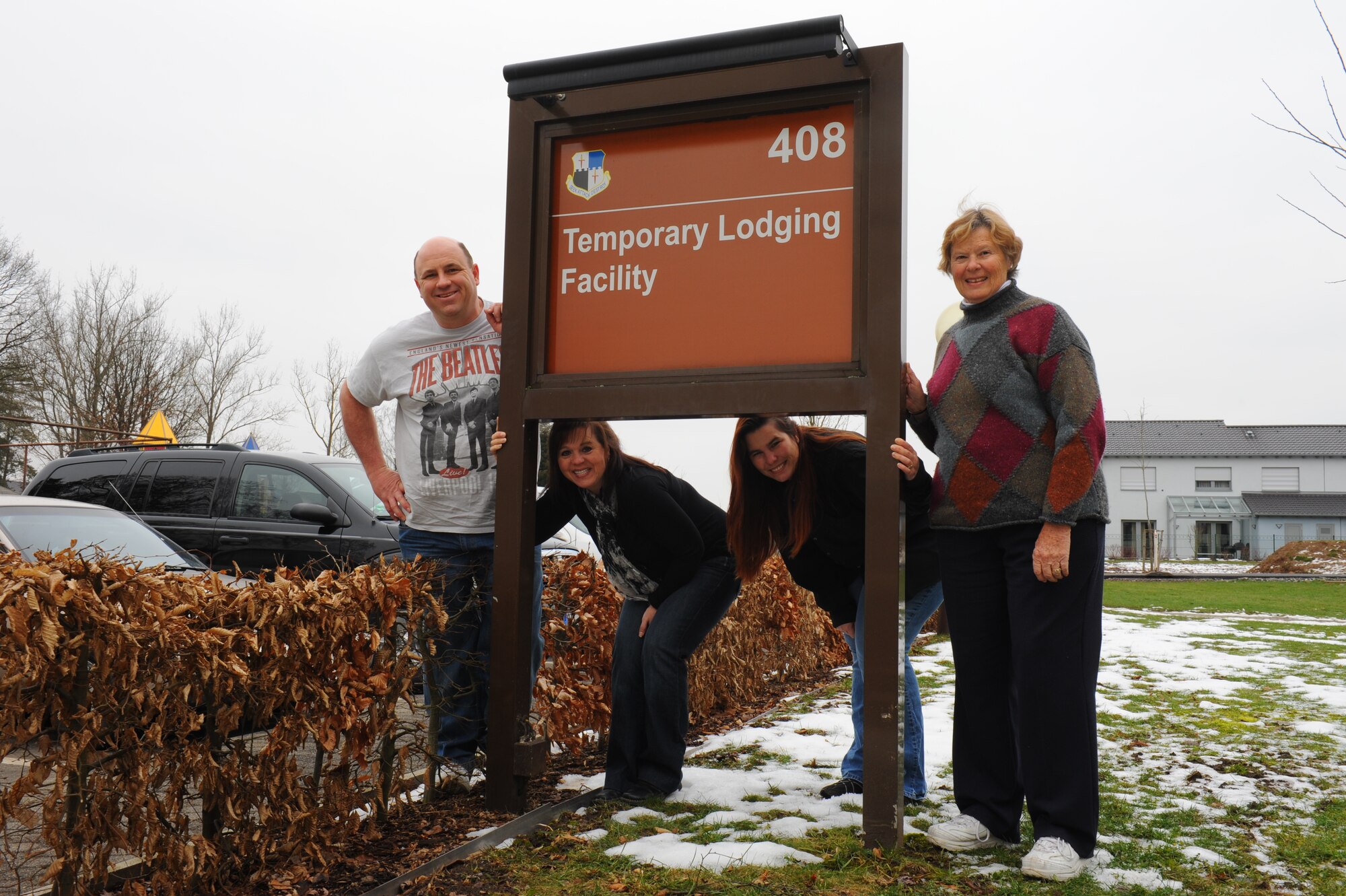 SPANGDAHLEM AIR BASE, Germany – Airman’s Attic volunteers, from left to right, Joe Deutschendorf, Brenda Jones, Krystal Baylor, and Wicky Seck, pose for a picture by their building sign Feb. 28. In the near future, the Airman’s Attic will move out of the basement of the temporary lodging facility to a more central location. (U.S. Air Force photo by Master Sgt. Kevin Nichols/Released)