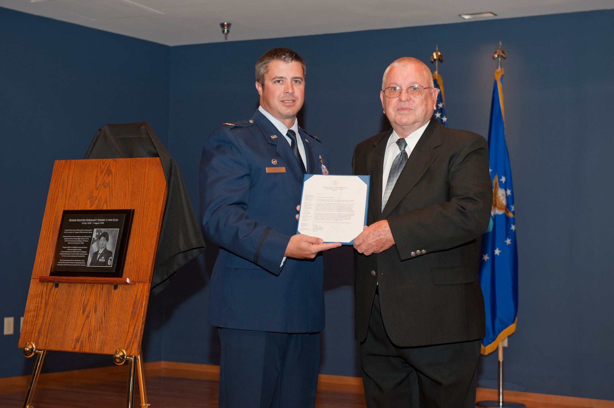 Col. David E. Graff, 325th Fighter Wing commander, presents Delbert Olds, father of Senior Master Sgt. Sherry Lynn Olds, a letter from Florida House Representative Jimmy Patronis during the dedication ceremony of a ballroom at Horizons Community Center for Sergeant Olds. The sergeant paid the ultimate price for her country and lost her life in the 1998 bombing of the U.S. Embassy in Nairobi, Kenya. (U.S. Air Force photo by Lisa Norman)