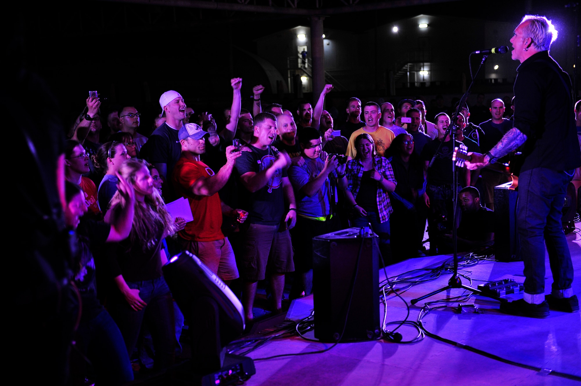 Members of the 380th Air Expeditionary Wing cheer and sing-along during an Everclear concert at an undisclosed location in Southwest Asia Mar. 10, 2013. Band members spent the day touring the installation and meeting Airmen and Soldiers, thanking them for their sacrifice and service. (U.S. Air Force photo by Tech. Sgt. Christina M. Styer/Released)