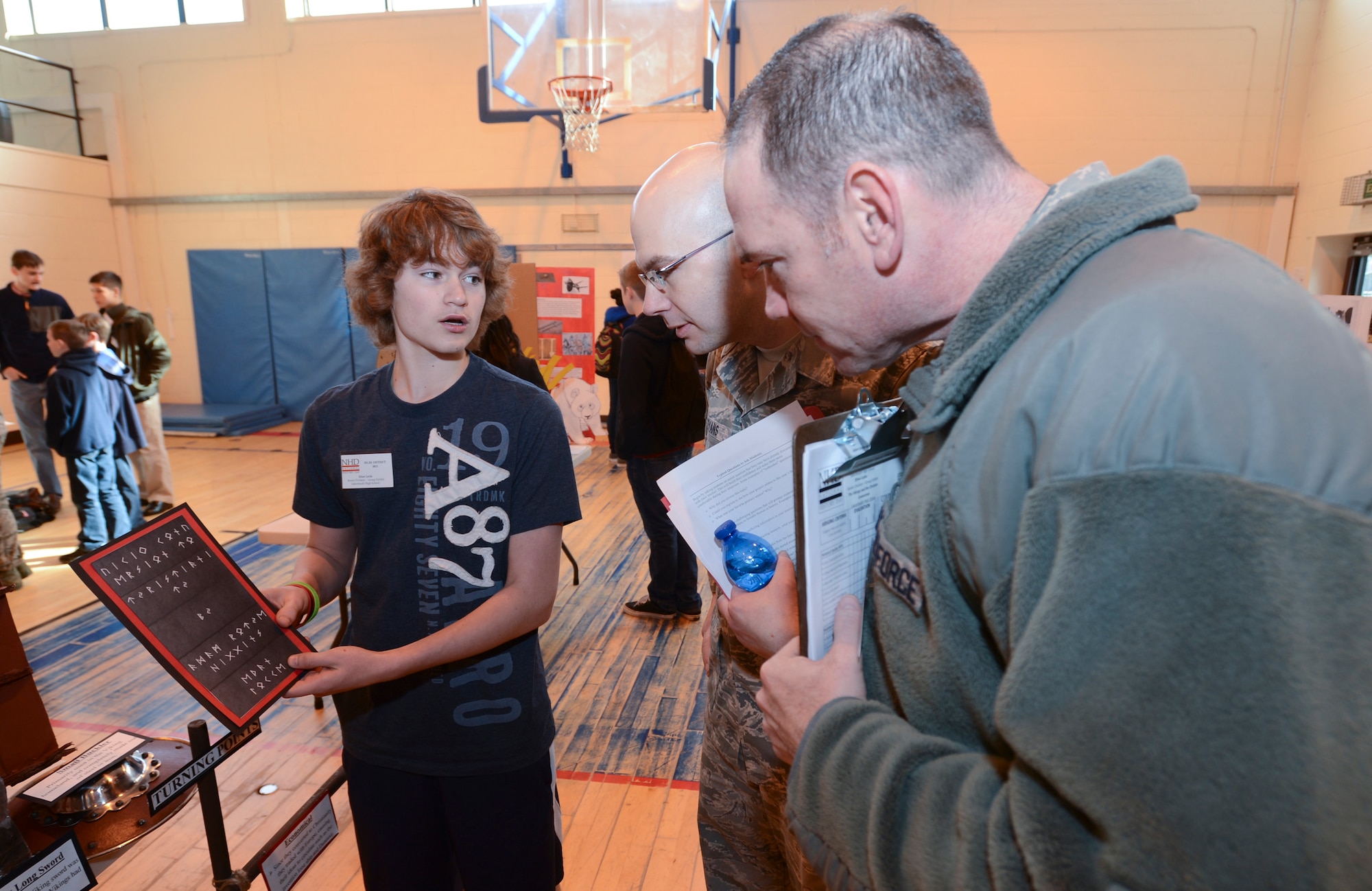 ROYAL AIR FORCE LAKENHEATH, England - Ethan Locke, 15, translates the "Viking Conversion to Christianity" exhibit's title slate, which is written in Old Norse, for judges during the 2nd Annual Isles District National History Day Showcase Feb. 28, 2013. Approximately 130 students from six Department of Defense Dependents Schools Isles District schools participated in the showcase. (U.S. Air Force photo by Staff Sgt. Stephen Linch)