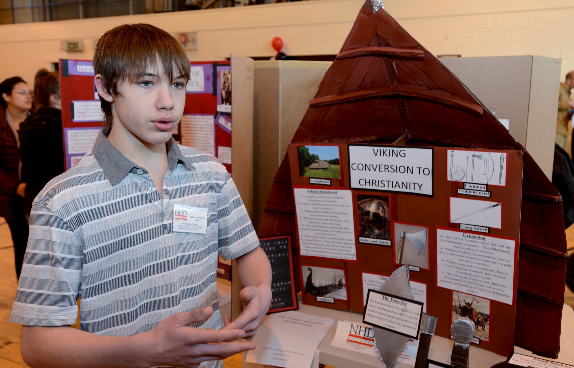 ROYAL AIR FORCE LAKENHEATH, England - Adam Roche-Higgins, 14, speaks to judges about his exhibit, "Viking Conversion to Christianity," during the 2nd Annual Isles District National History Day Showcase Feb. 28, 2013. Students worked individually or in groups of two or three to make projects such as exhibits, documentaries, research papers and websites based on this year's showcase theme, "Turning Points in History."(U.S. Air Force photo by Staff Sgt. Stephen Linch)
