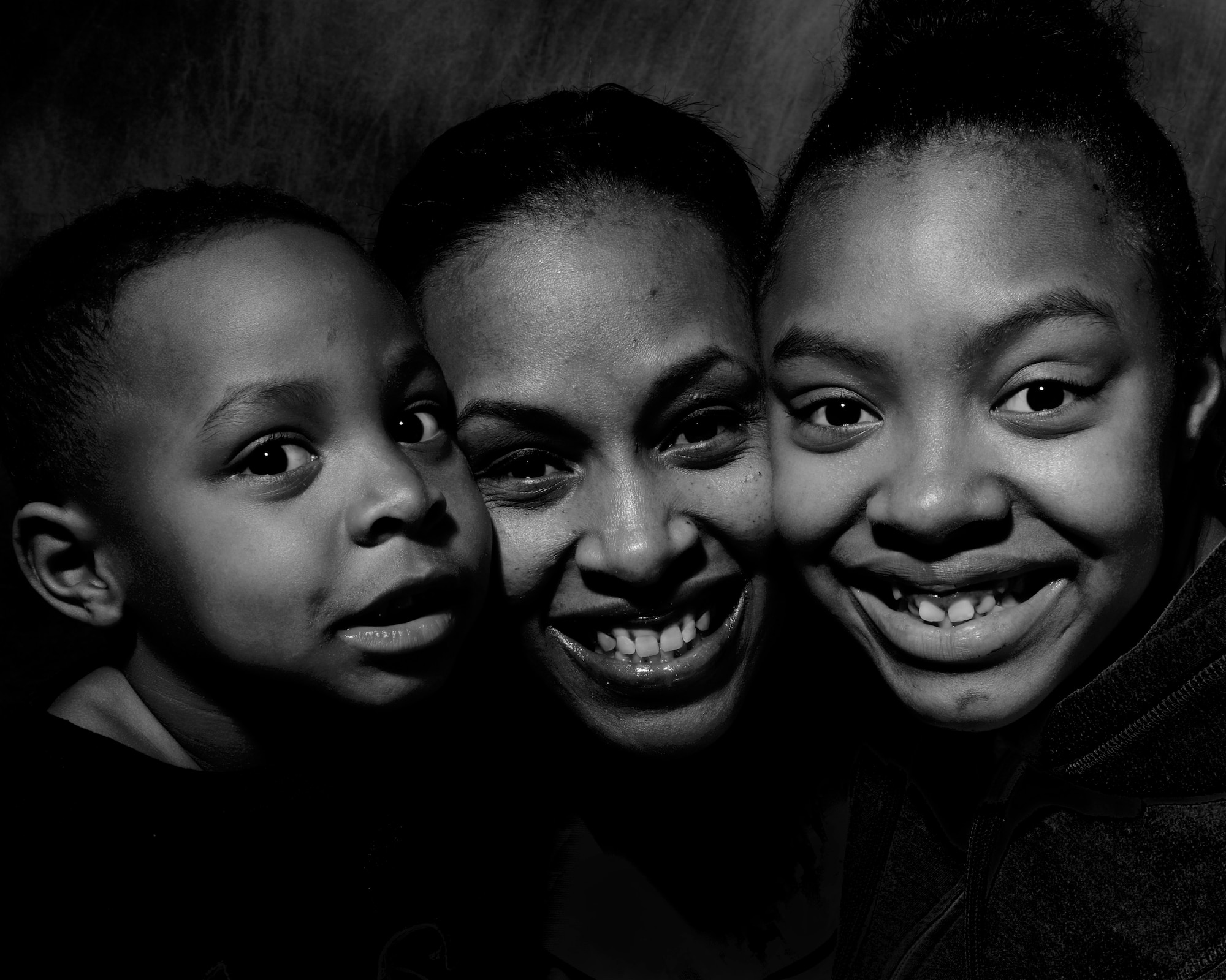 ROYAL AIR FORCE LAKENHEATH, England - Tech. Sgt. Tanya Evans, 48th Logistics Readiness Squadron Traffic Management Office receiving and inbound NCO in charge, and her two kids Marquis and Tierra pose for a photo March 11, 2013.  Evans says she now sees the life through six eyes instead of two. Her story of overcoming a domestic abuse is one of several being featured during Womens' History Month. (U.S. Air Force photo by Staff Sgt. Stephanie Mancha)