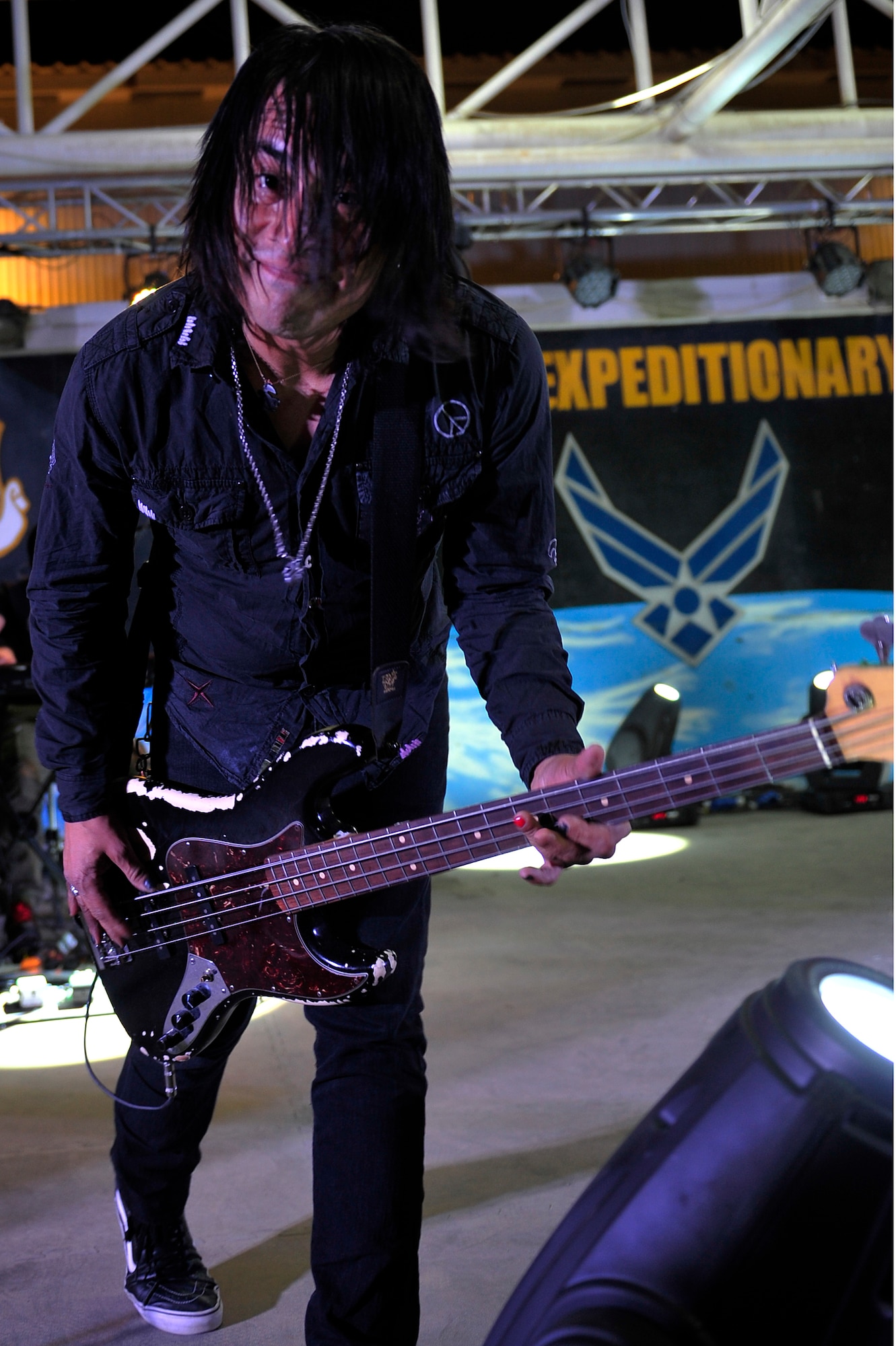 Freddie Herrera, back-up vocals and bass, of the American rock band Everclear performs a solo during a concert for the men and women of the 380th Air Expeditionary Wing at an undisclosed location in Southwest Asia Mar. 10, 2013. Band members spent the day touring the installation and meeting Airmen and Soldiers, thanking them for their sacrifice and service. (U.S. Air Force photo by Tech. Sgt. Christina M. Styer/Released)