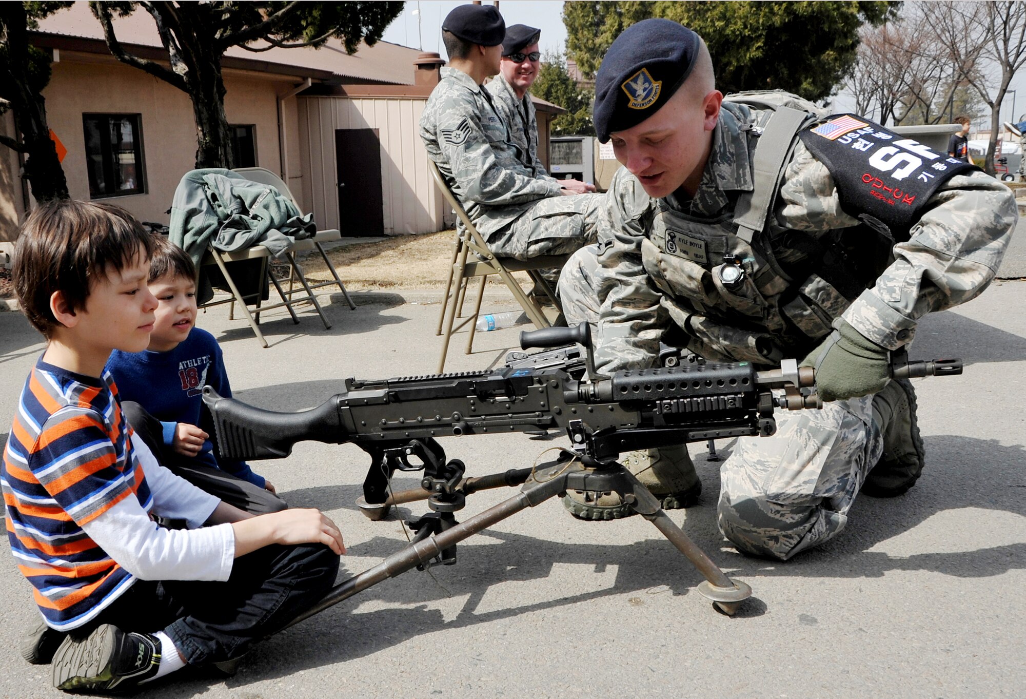 Airman Kyle Boyle, 51st Security Forces Squadron entry controller, displays a M-240B Machine Gun to Team Osan youth at Defender’s Day at Bldg. 1425 March 9, 2013. The weapons demonstration was a popular activity at the event, giving participants a close up look at the .50 Caliber and M-249 Machine Guns and the MM-K19. (U.S. Air Force photo/Senior Airman Kristina Overton)