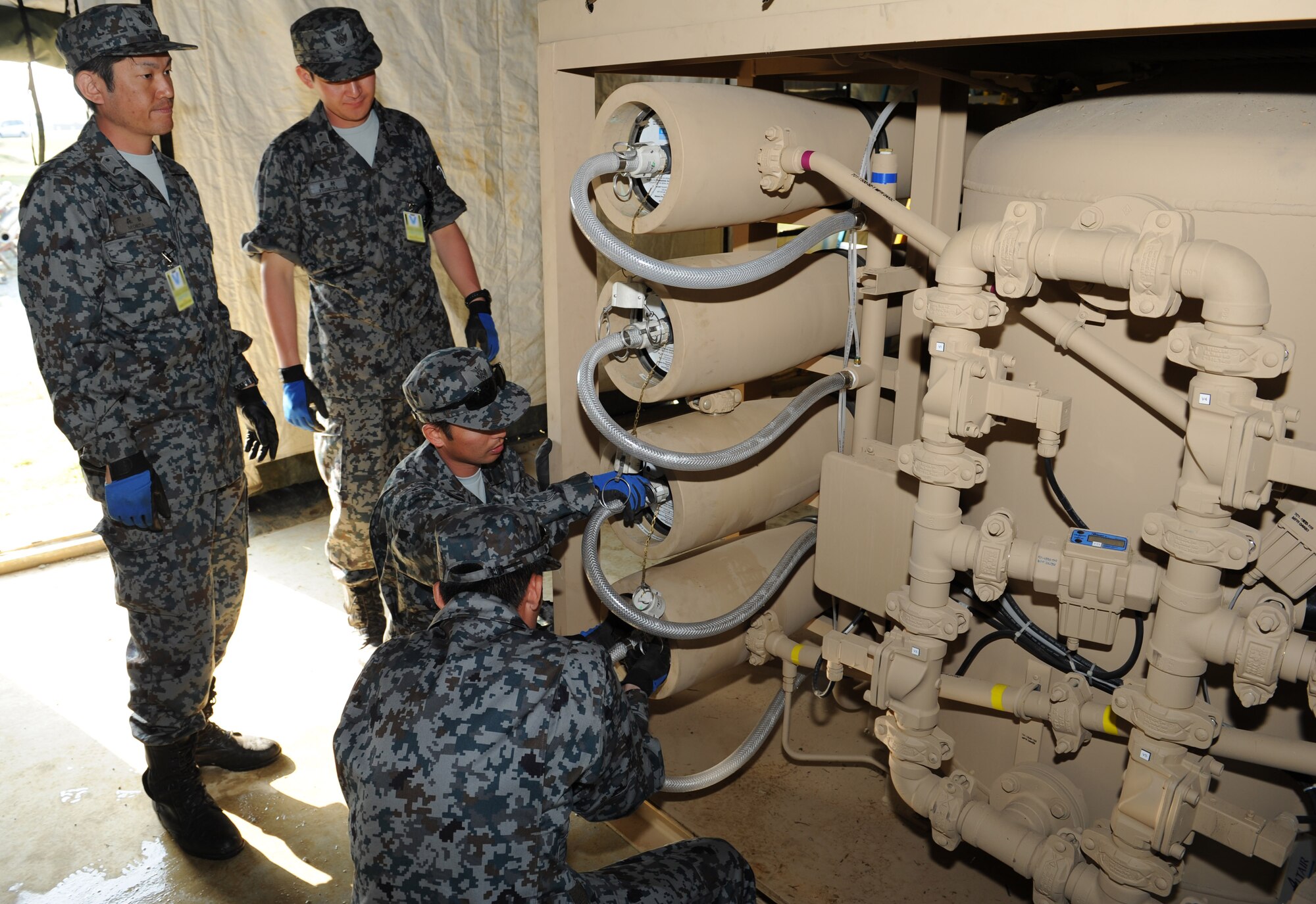 Japan Air Self Defense Force members work on how to repair and maintain a reverse osmosis water purification unit on Kadena Air Base, Japan, March 8, 2013. The JASDF and Detachment 1 554th RED HORSE Squadron joint training included learning how to repair and maintain a unit to ensure clean water is available during contingency operations. (U.S. Air Force photo/Airman 1st Class Keith A. James)