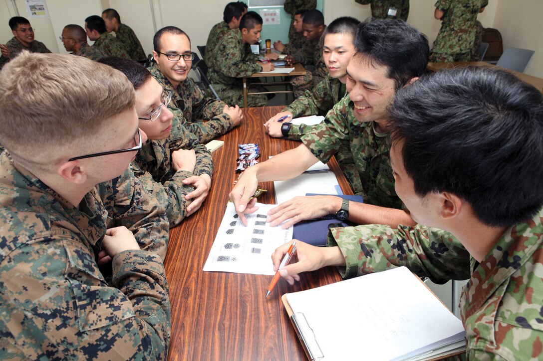 Japan Ground Self-Defense Force members and U.S. Marines and sailors teach each other English and Japanese languages during a cultural exchange event March 7 at Camp Naha. The two-day event, which was conducted at both Camp Naha and Camp Kinser, was designed to allow U.S. and JGSDF service members  to practice basic English and Japanese language skills and develop cultural awareness. 