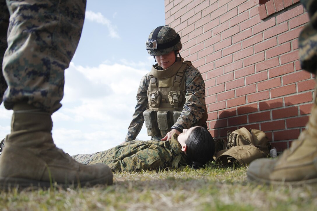 Cpl. Stephanie Abelino, a Marine Aircraft Group 14 warehouse clerk, checks the vitals on a victim with a simulated injury during a combat lifesaver course conducted aboard Marine Corps Auxiliary Landing Field Bogue March 6. 

