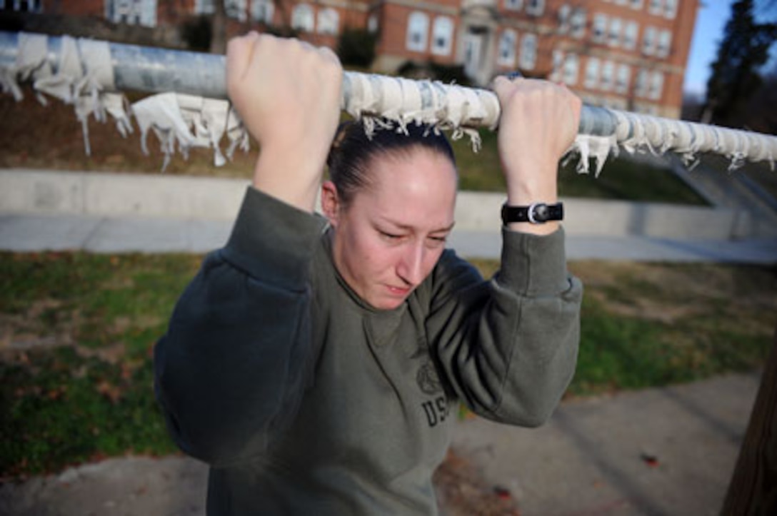Sgt. Stephany Rector, administrative specialist, installation personnel administration center, Headquarters Company, Headquarters and Service Battalion, completes pull-ups outside of her office, Dec. 3. Starting Jan. 1, 2014, female Marines, poolees, and officer candidates will perform dead-hang pull-ups rather than the flexed arm-hang during their physical fitness tests.  
