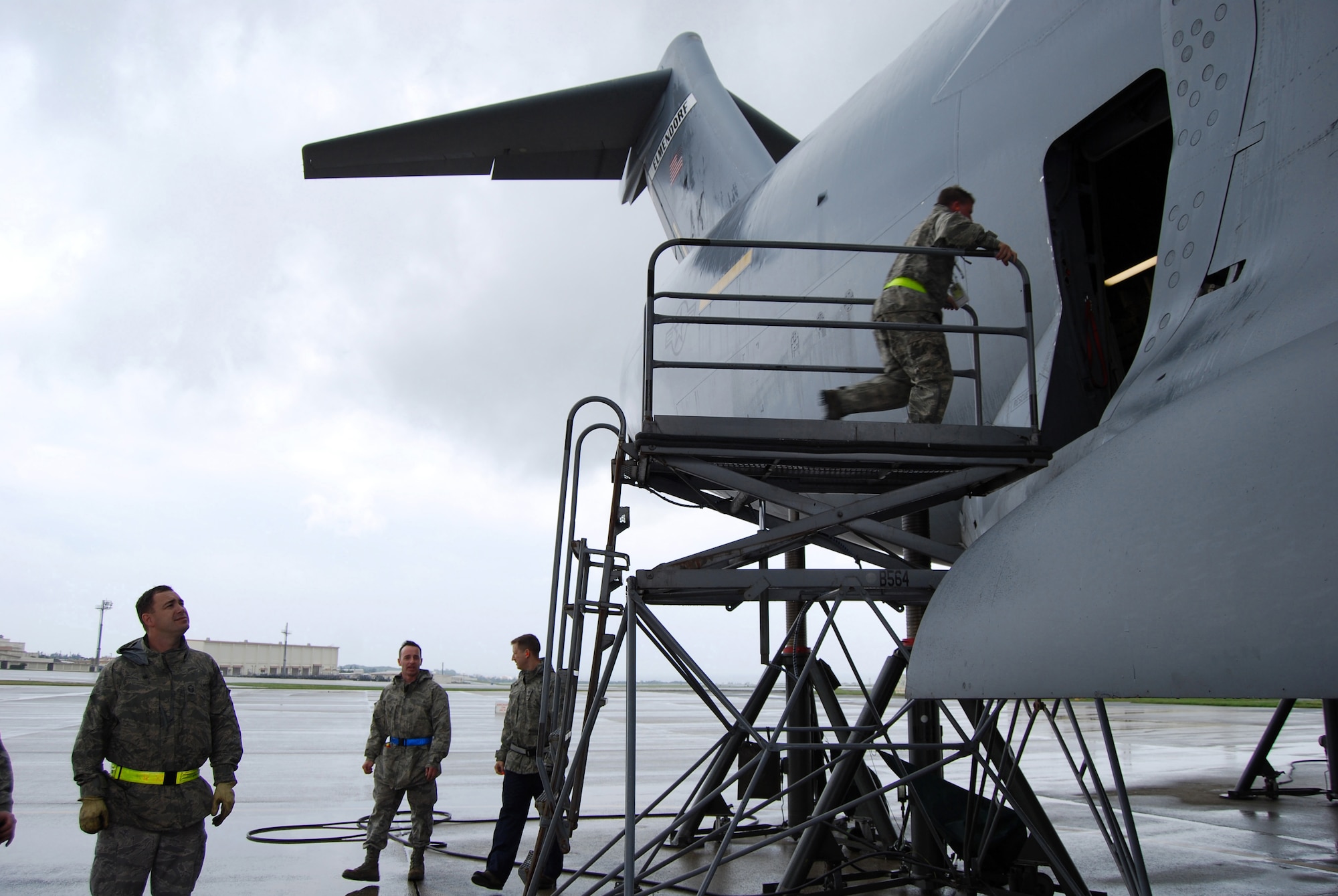 U.S. Air Force Master Sgt. Charles Burnett, from the 733rd Air Mobility Squadron, enters  a jacked C-17 Globemaster III airlift aircraft on the Kadena Air Base, Japan, flightline to check alignment as Master Sgt. Timothy Bugg, Master Sgt. Jeffery Parker and Tech. Sgt. Michael Pitt, also from the 733rd AMS, look on. The 733rd AMS maintenance flight's 70 maintainers must be ready to work on many types of aircraft across varied specialties, such as crew chiefs, engines, communications and navigation, electrical and environmental systems, hydraulics, and maintenance analysis. (U.S. Air Force courtesy photo)