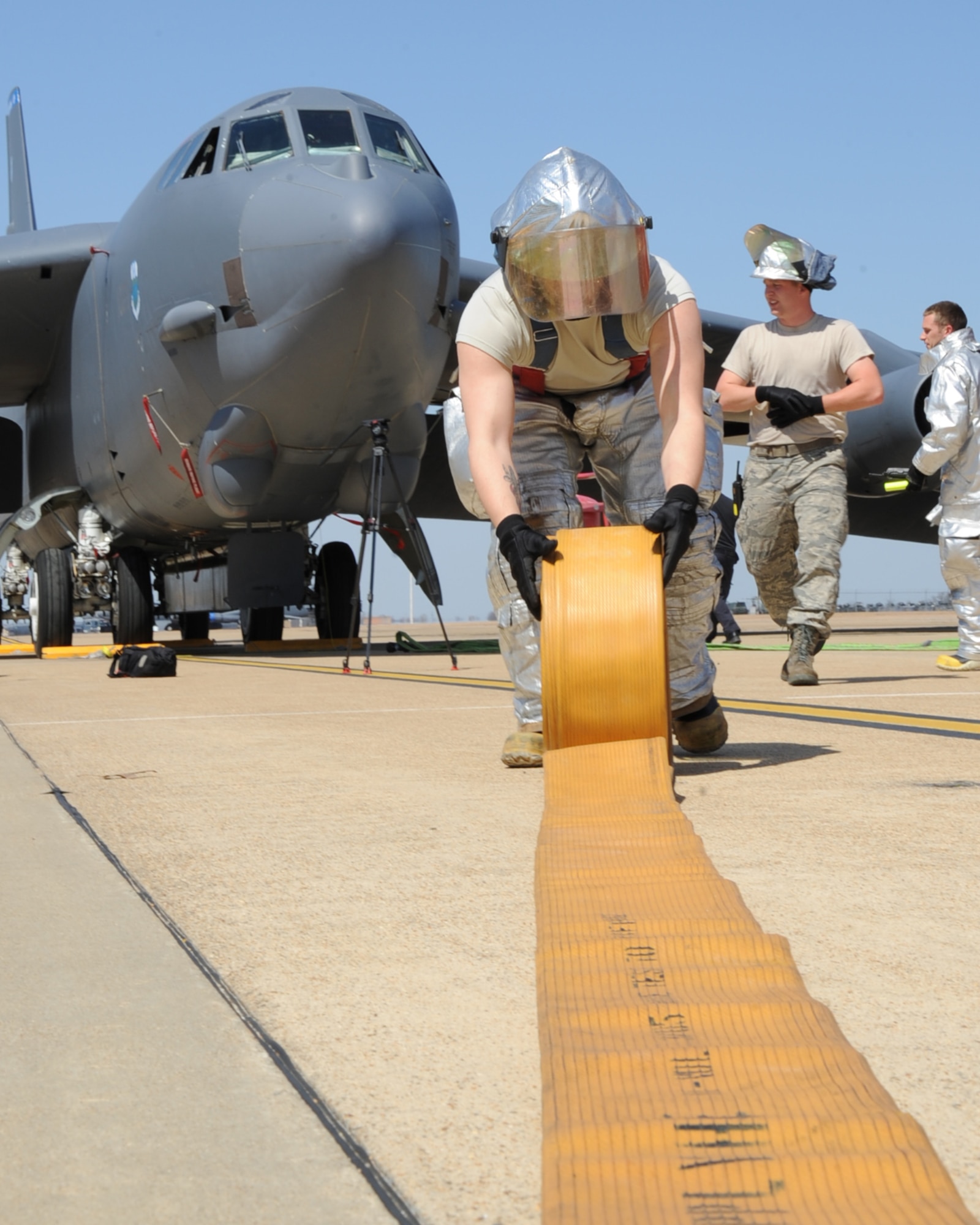 A firefighter from the 2nd Civil Engineer Squadron, rolls up a hose during an aircraft egress exercise on Barksdale Air Force Base, La., March 14. The exercise ensured firefighters are trained and ready in the event of a real world emergency. (U.S. Air Force photo/Senior Airman Sean Martin)