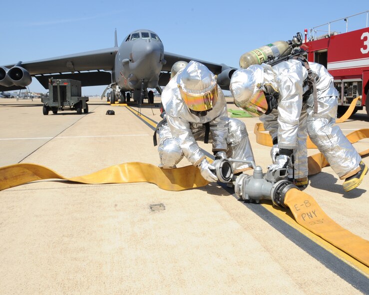 Two firefighters from the 2nd Civil Engineer Squadron attach hoses to a coupling during an aircraft egress exercise on Barksdale Air Force Base, La., March 14. The training was held to provide firefighters hands-on training with their tools and equipment, allowing them to become proficient at their craft.  (U.S. Air Force photo/Senior Airman Sean Martin)