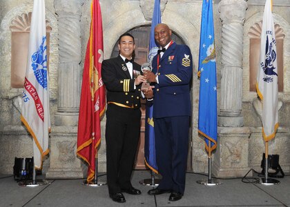 Coast Guard Cmdr. Eugenio Anzano, U.S. Coast Guard Cryptologic Unit senior commanding officer, presents Lt. Lance Leone, Coast Guard Medical Liaison officer, with the Coast Guard company grade officer of the year award.