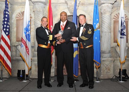 Rear Adm. William Roberts, Medical Education and Training Campus commandant, and Master Chief Petty Officer Rusty Perry, Navy Medicine Education and Training Command command master chief, present Curtis Davis, NMETC, with the Navy civilian supervisory category II of the year award.