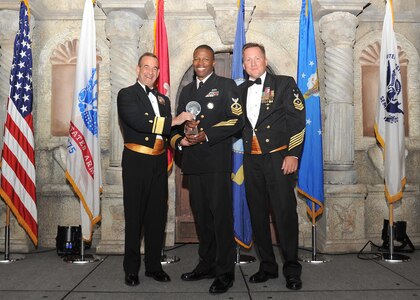 Rear Adm. William Roberts, Medical Education and Training Campus commandant, and Master Chief Petty Officer Rusty Perry, Navy Medicine Education and Training Command command master chief, present Chief Petty Officer Rodney Hopes, Navy Operational Support Center, with the Navy large unit first sergeant of the year award.