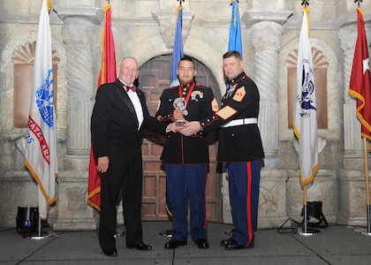 Retired Marine Sgt. Maj. Harold G. Overstreet, 12th Sergeant Major of the Marine Corps, and Sgt. Maj. Gary Tolar, U.S. Marine Corps 4th Reconnaissance Battalion inspector-instructor sergeant major, present Gunnery Sgt. John Herrerra, 4th Reconnaissance Battalion, with the Marine senior enlisted member of the year award.