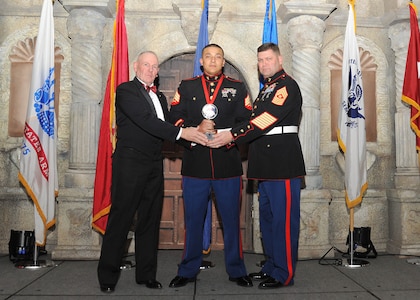 Retired Marine Sgt. Maj. Harold G. Overstreet, 12th Sergeant Major of the Marine Corps, and Sgt. Maj. Gary Tolar, U.S. Marine Corps 4th Reconnaissance Battalion inspector-instructor sergeant major, present Sgt. Deyvi Gomez Mondragon, 4th Reconnaissance Battalion, with the Marine NCO of the year award.