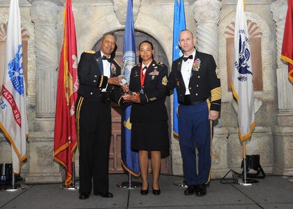 Army Maj. Gen. Adolph McQueen, U.S. Army North deputy commanding general support, and Command Sgt. Maj. Rodney Rhoades, Mission and Installation Contracting Command command sergeant major, present 1st Sgt. Mildred Lara, U.S. Army South, with the Army small unit first sergeant of the year award.