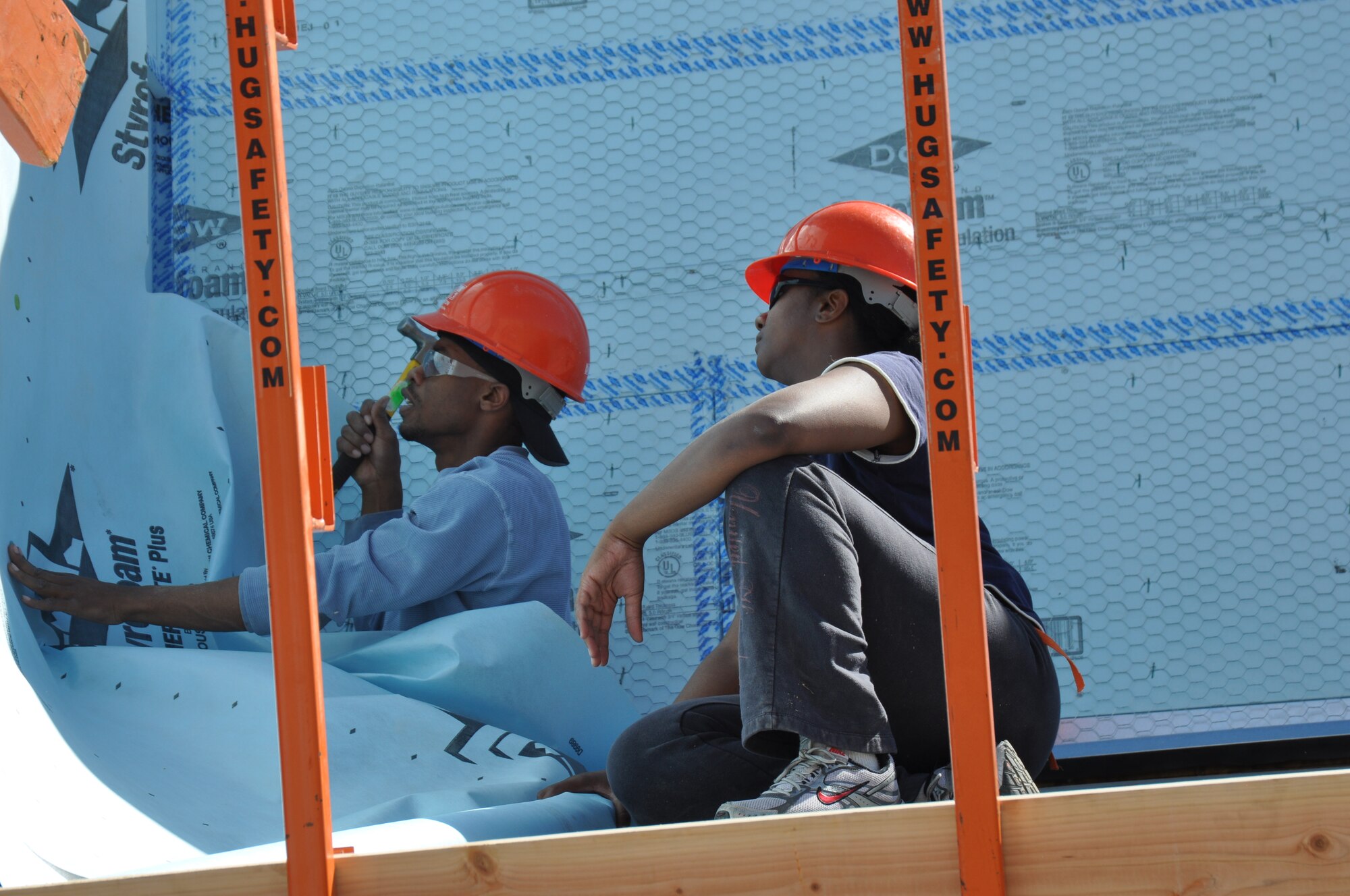 Airmen from the 612th Air and Space Operations Center, 355th Equipment Maintenance Squadron and the 355th Component Maintenance Squadron, hang sheets of stucco preparation paper on the exterior of a Habitat Humanity house in Tucson, Ariz., March 14. More than 45 Airmen from Davis-Monthan AFB came together to donate six hours of their off-duty time to build homes in support of the local community. (USAF photo by Master Sgt. Kelly Ogden/Released).