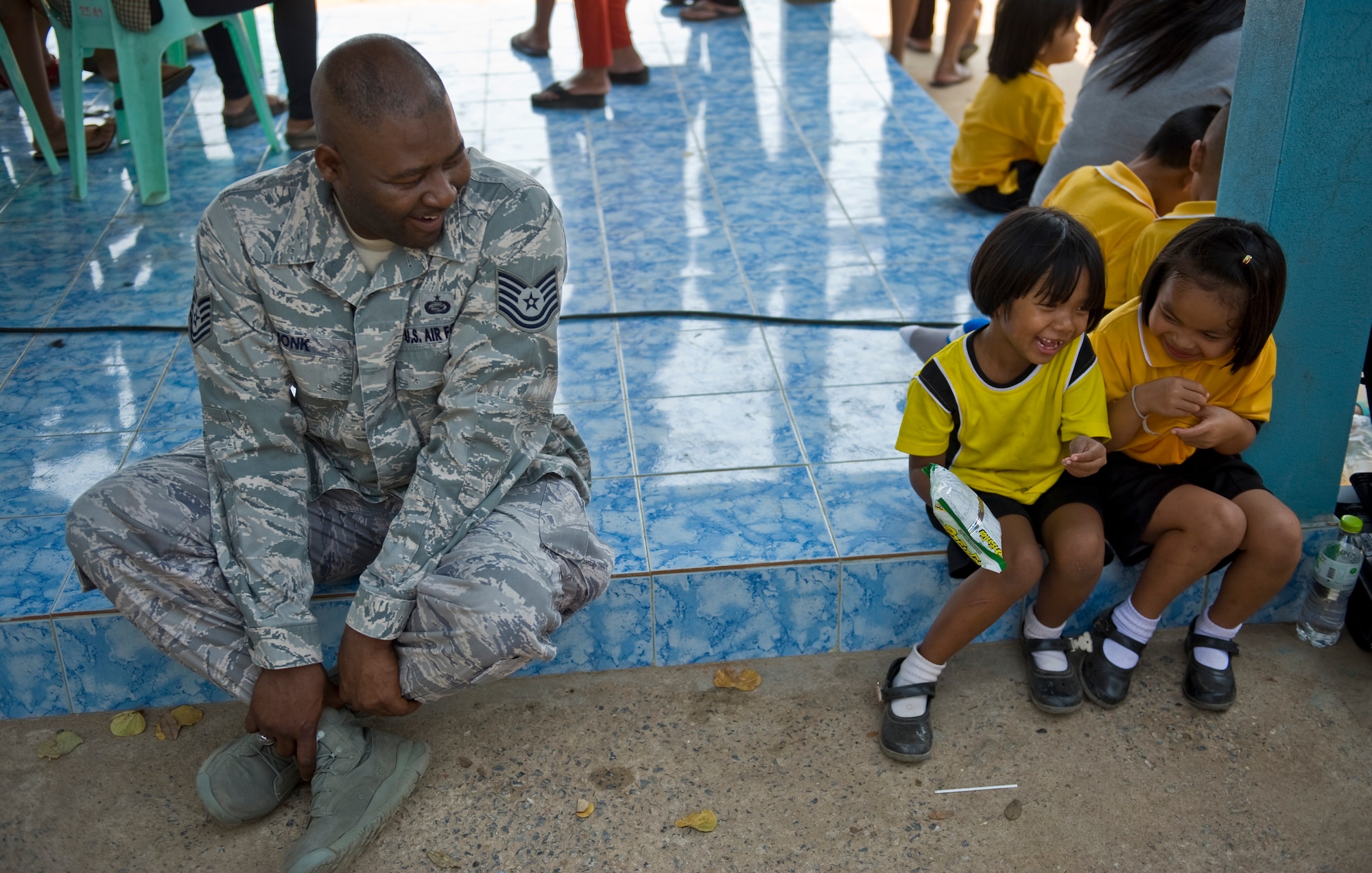 U.S. Air Force Tech. Sgt. Monk, a personnel specialist, sits beside Thai students as Cope Tiger 13 participants from the U.S. Air Force, Royal Thai Air Force and Republic of Singapore Air Force visit Ban Palai School in Nakhon Ratchasima Province, Thailand, March 13, 2013. Airmen from each country donated computer equipment, school supplies, and athletic gear to the school during the multilateral engagement. The Airmen were welcomed with warm hospitaility and Thai cultural performances. More than 300 U.S. service members are participating in CT13, which offers an unparalleled opportunity to conduct a wide spectrum of large force employment air operations and strengthen military-to-military ties with two key partner nations, Thailand and Singapore. (U.S. Air Force photo/2nd Lt. Jake Bailey)