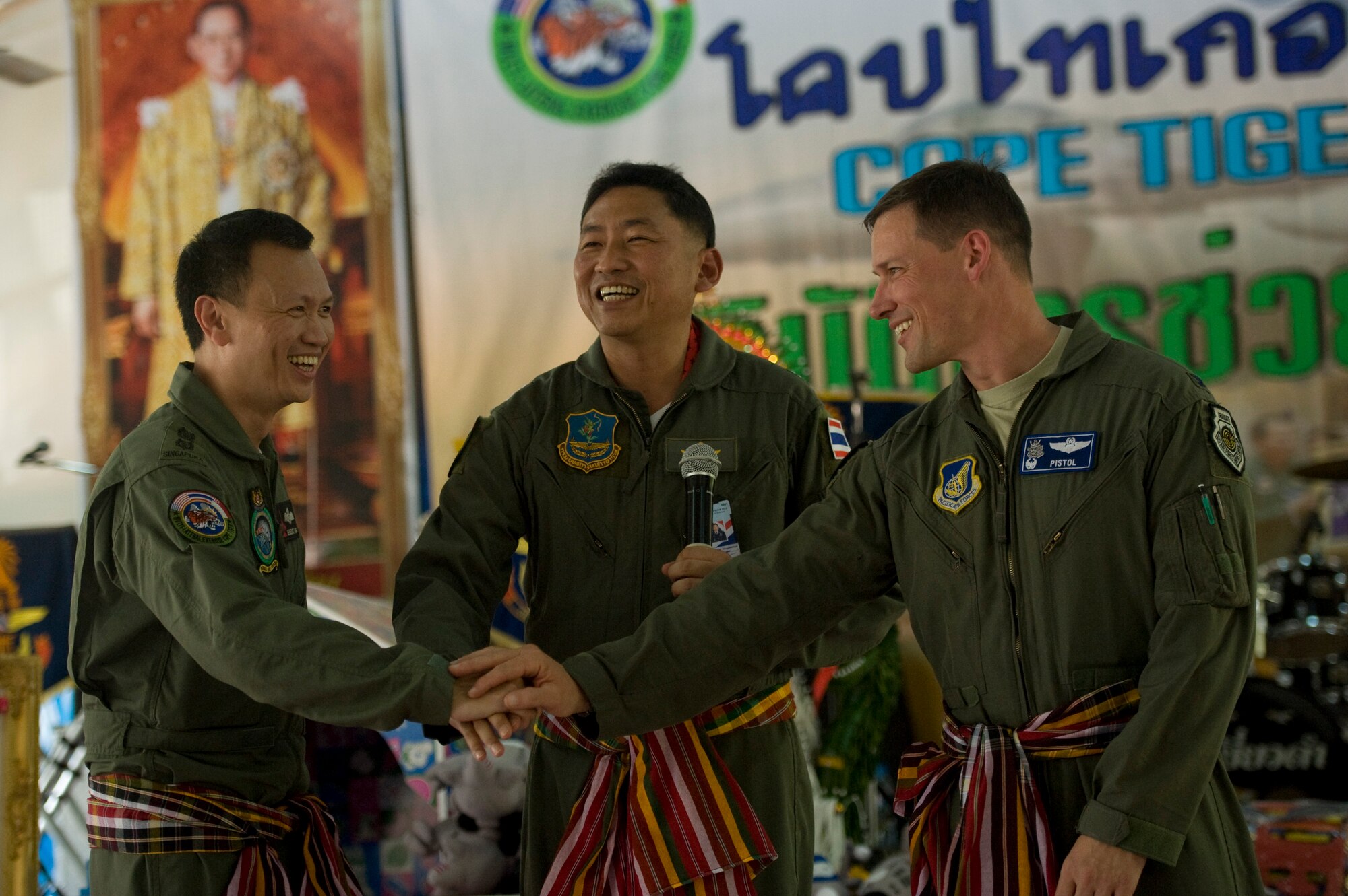 Cope Tiger 13 exercise directors from the U.S. Air Force, Royal Thai Air Force and Republic of Singapore Air Force join hands during a visit to Ban Palai School in Nakhon Ratchasima Province, Thailand, March 13, 2013. Airmen from each country donated computer equipment, school supplies, and athletic gear to the school during the multilateral engagement. More than 300 U.S. service members are participating in CT13, which offers an unparalleled opportunity to conduct a wide spectrum of large force employment air operations and strengthen military-to-military ties with two key partner nations, Thailand and Singapore. (U.S. Air Force photo/2nd Lt. Jake Bailey)