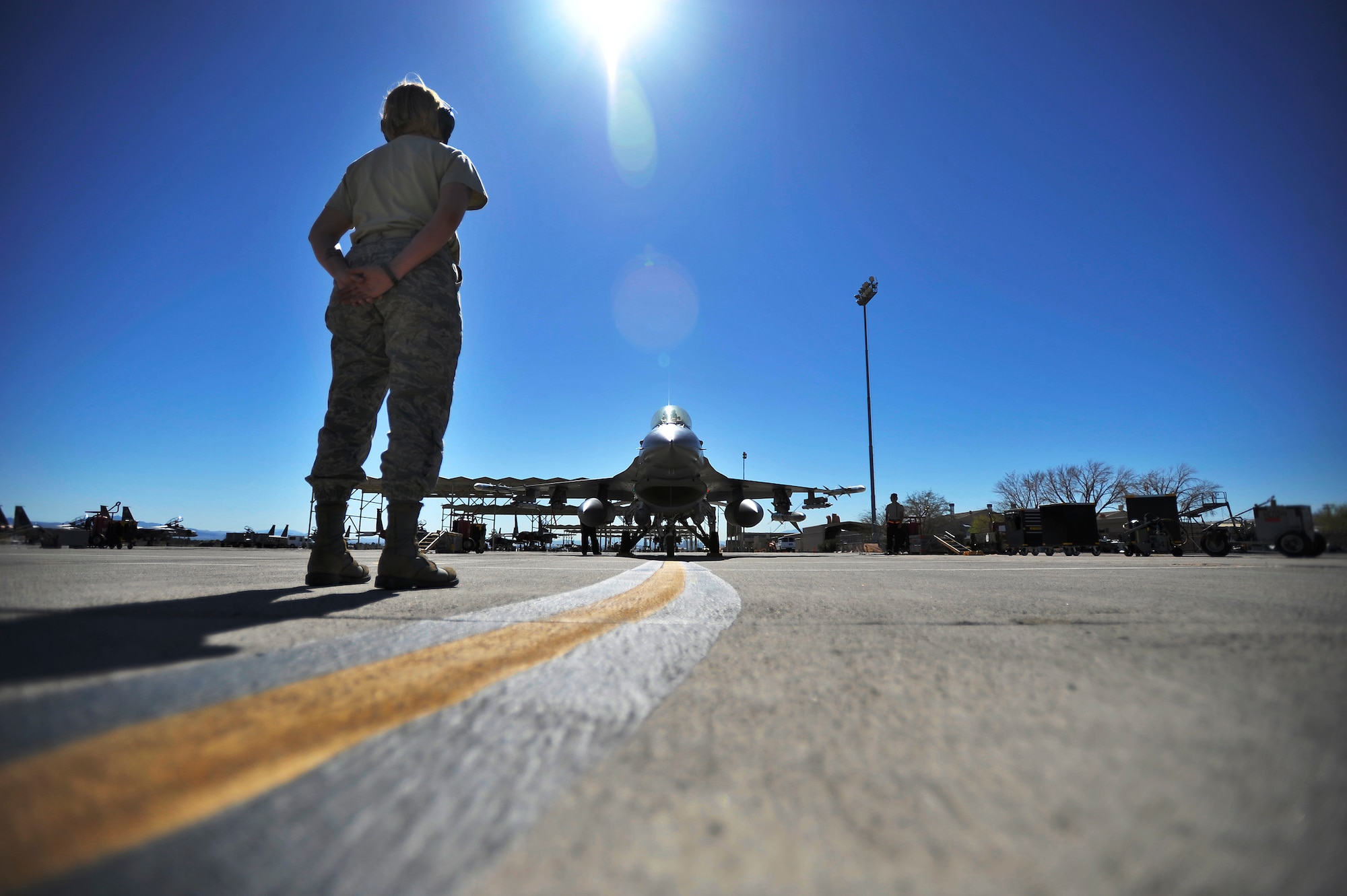 U.S. Air Force Staff Sgt. Elizabeth Tyburski, 20th Communications Squadron client service technician, stands in position to marshall a 79th Fighter Squadron ‘Tigers’ F-16 Fighting Falcon during Red Flag 13-3, March 12, 2013, Nellis Air Force Base, Nev. Tyburski received the rare opportunity to launch an F-16 and experienced what it’s like to be a crew chief. (U.S. Air Force photo by Staff Sgt. Kenny Holston/Released)