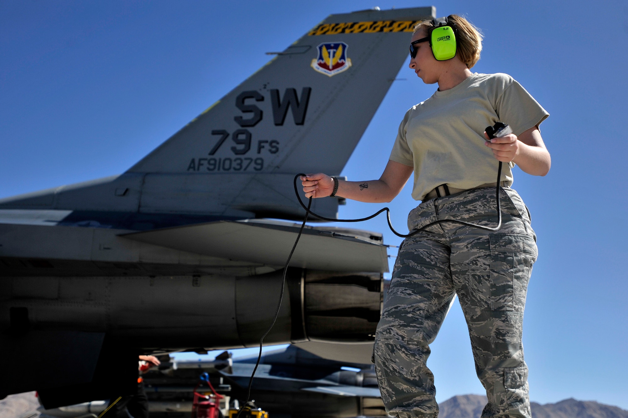 U.S. Air Force Staff Sgt. Elizabeth Tyburski, 20th Communications Squadron client service technician, hooks up her communication cord so she is able to talk to 1st Lt. Phill Wilson, 79th Fighter Squadron pilot, prior to him taking off during Red Flag 13-3, March 12, 2013, Nellis Air Force Base, Nev. Tyburski received the rare opportunity to launch an F-16 and experienced what it’s like to be a crew chief. (U.S. Air Force photo by Staff Sgt. Kenny Holston/Released)