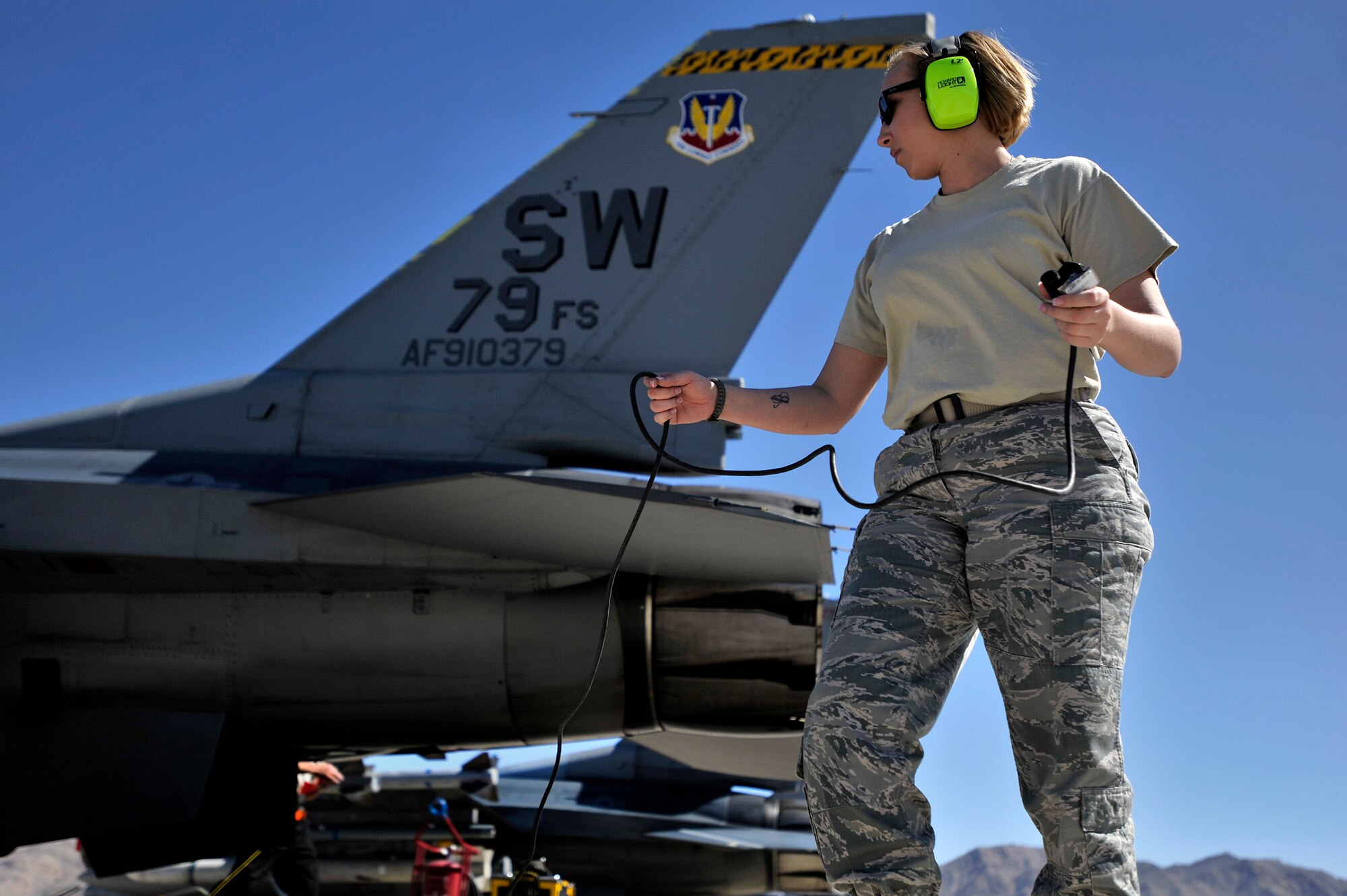 U.S. Air Force Staff Sgt. Elizabeth Tyburski, 20th Communications Squadron client service technician, hooks up her communication cord so she is able to talk to 1st Lt. Phill Wilson, 79th Fighter Squadron pilot, prior to him taking off during Red Flag 13-3, March 12, 2013, Nellis Air Force Base, Nev. Tyburski received the rare opportunity to launch an F-16 and experienced what it’s like to be a crew chief. (U.S. Air Force photo by Staff Sgt. Kenny Holston/Released)