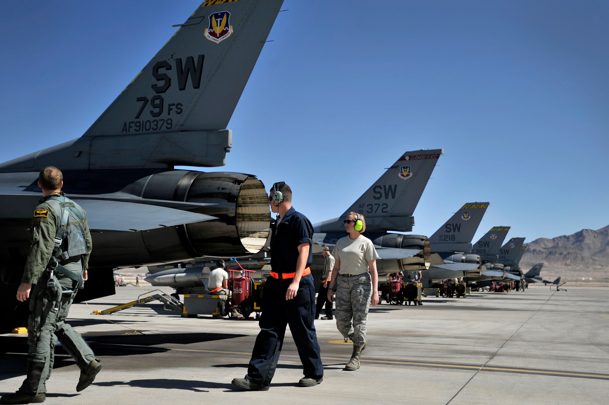 1st Lt. Phill Wilson, 79th Fighter Squadron pilot, (left), Staff Sgt. Dominic Perrone, 20th Aircraft Maintenance Squadron crew chief, (center) and Staff Sgt. Elizabeth Tyburski, 20th Communications Squadron client service technician, inspect a 79th Fighter Squadron ‘Tigers’ F-16 Fighting Falcon during Red Flag 13-3, March 12, 2013, Nellis Air Force Base, Nev. Tyburski received the rare opportunity to launch an F-16 and experienced what it’s like to be a crew chief. (U.S. Air Force photo by Staff Sgt. Kenny Holston/Released)