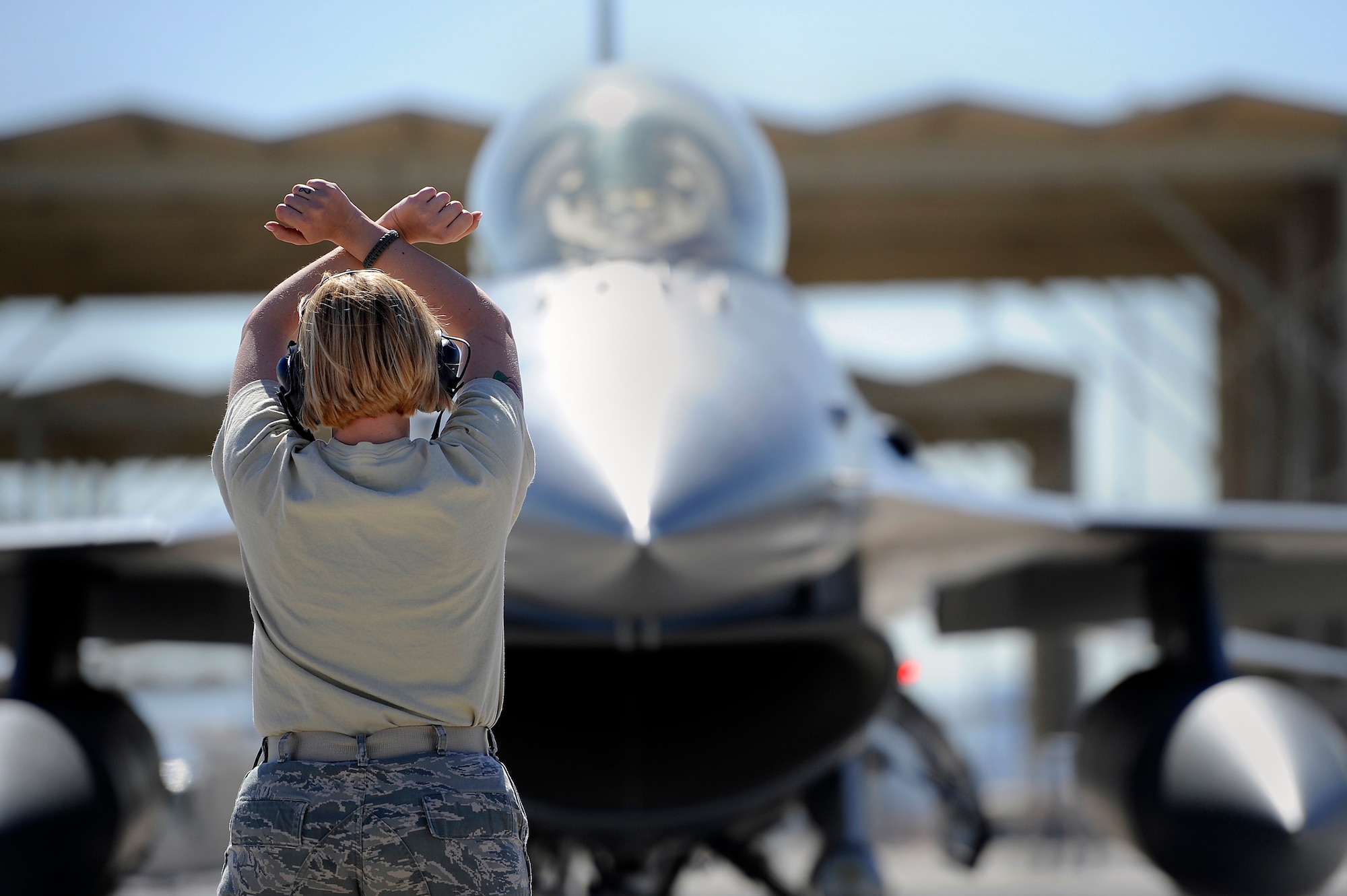 U.S. Air Force Staff Sgt. Elizabeth Tyburski, 20th Communications Squadron client service technician, marshalls a 79th Fighter Squadron ‘Tigers’ F-16 Fighting Falcon during Red Flag 13-3, March 12, 2013, Nellis Air Force Base, Nev. Tyburski received the rare opportunity to launch an F-16 and experienced what it’s like to be a crew chief. (U.S. Air Force photo by Staff Sgt. Kenny Holston/Released)