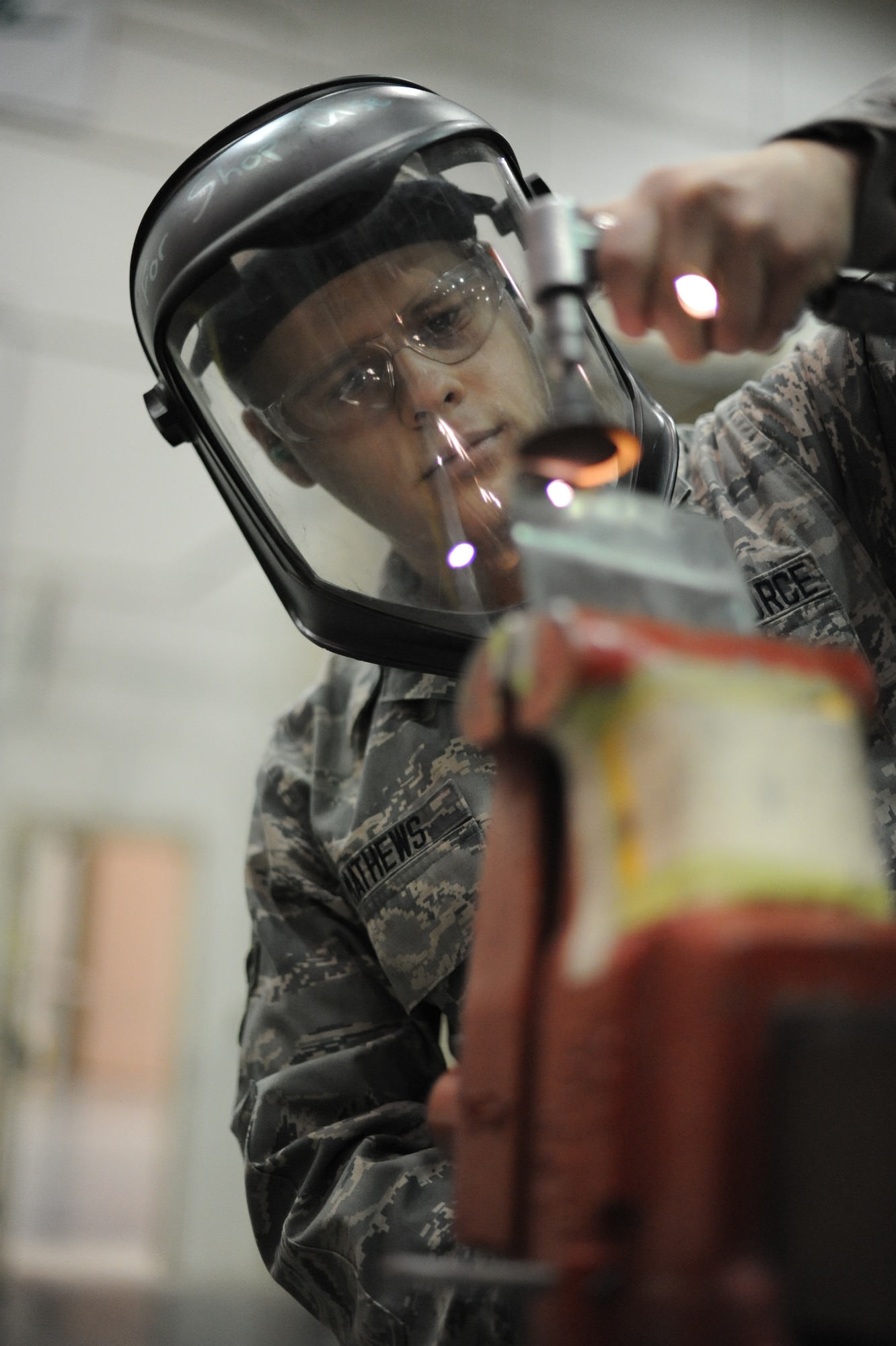 Airman 1st Class Brandon Mathews, 305th Aircraft Maintenance Squadron Fabrication Flight structural aircraft maintainer, grinds a piece of titanium for training purposes Feb. 21, 2013, at Joint Base McGuire-Dix-Lakehurst, N.J. The Cumland, Mo., native works in the only maintenance shop on JB MDL that makes its supplies for aircraft maintenance, as opposed to ordering the supplies from an outside source. (U.S. Air Force photo by Airman Sean M. Crowe/Released)