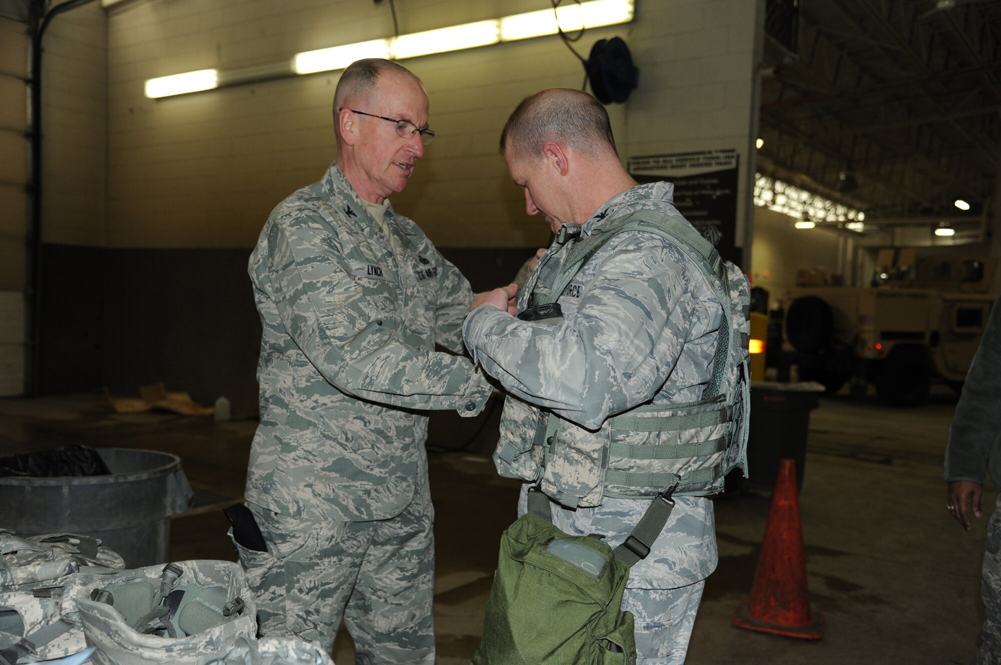 Col. David Lynch, 341st Security Forces Group commander, left, fits a flak vest on Col. Robert Stanley, 341st Missile Wing commander, at the Vehicle Readiness Center. Stanley and Malmstrom Air Force Base security forces members received Humvee Egress Assistance Training, which simulates a vehicle rollover. (U.S. Air Force photo/Airman 1st Class Katrina Heikkinen)