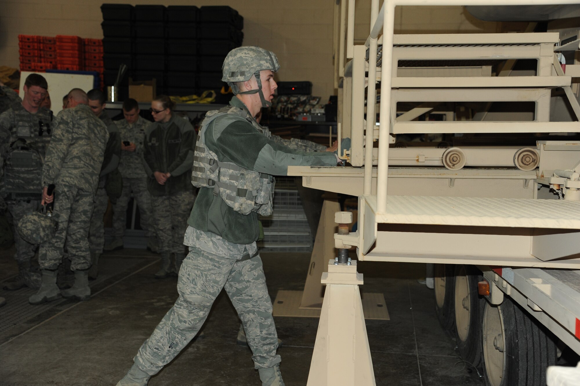 Airman Kyle Roth, 341st Missile Security Forces Squadron member, pushes a ramp underneath the Humvee Egress Assistance Trainer so that the Airmen inside the trainer can exit safely during a scenario. Malmstrom’s security forces members were tasked with executing an egress from the HEAT in two scenarios: one when the vehicle was lying on its side and one when the vehicle was upside down. (U.S. Air Force photo/Airman 1st Class Katrina Heikkinen)