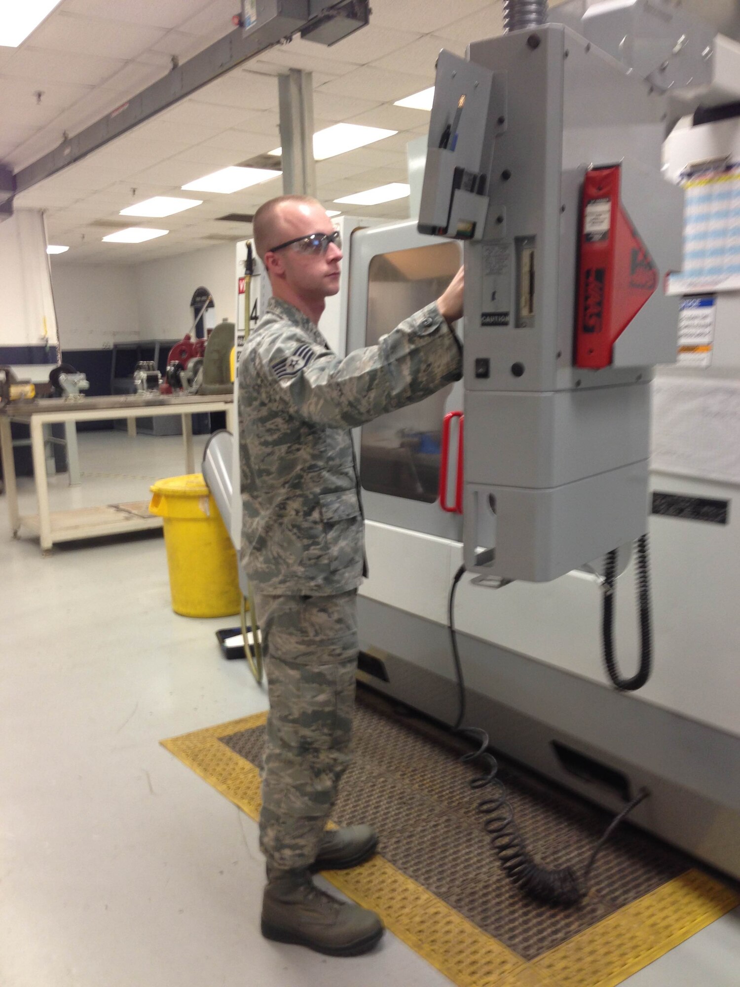 Staff Sgt. Michael Johnson programs a CNC machine, which uses comptroller instructions to mill metal. (courtesy photo)