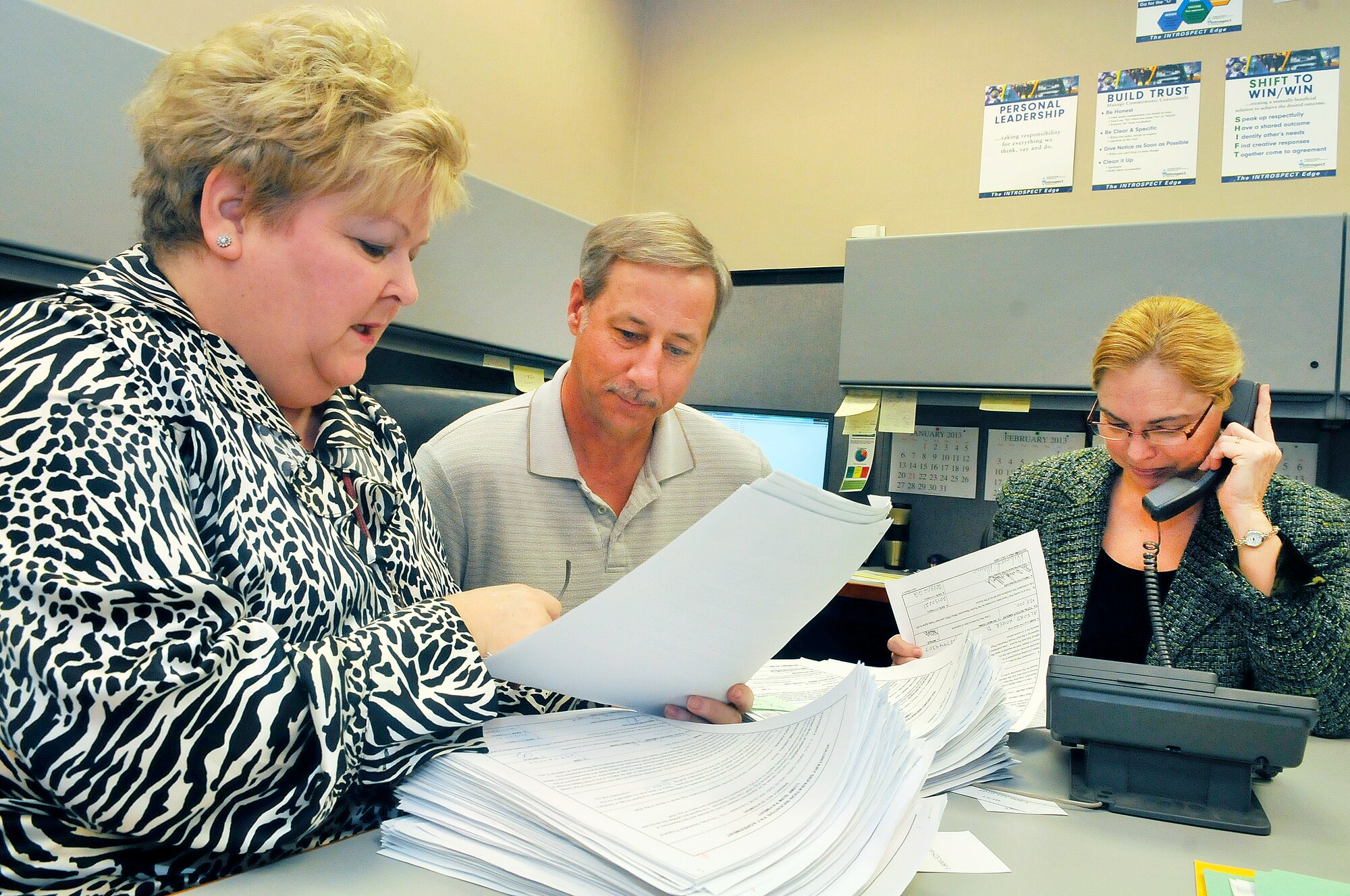 L-R, Nancy Moody, John Shoenfelt and Tracy Barnes, human resource specialists, go through a stack of conditions for acceptance for VSIP. (U. S. Air Force photo/Sue Sapp)