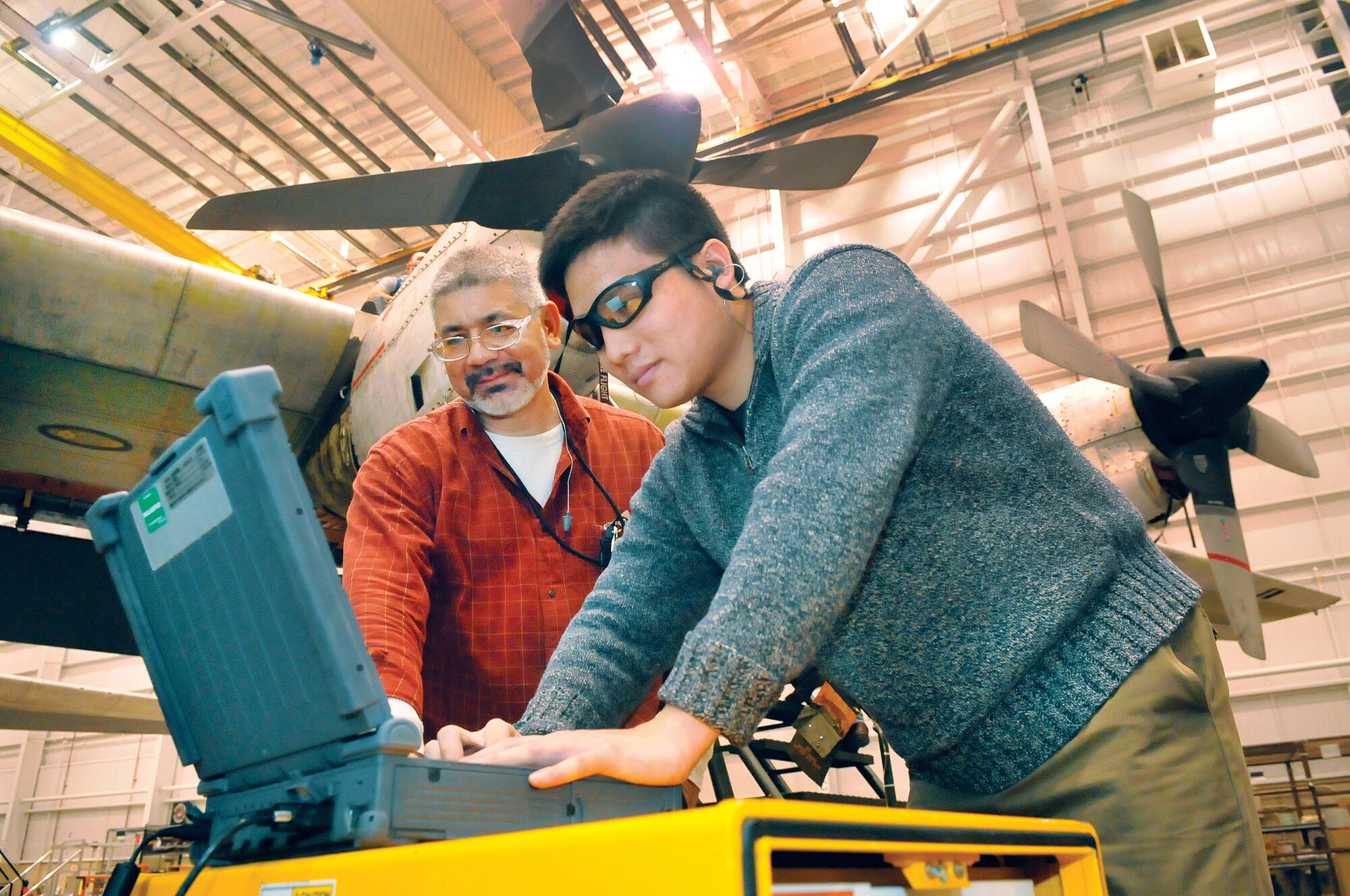 L-R, Efran Rangel and Jikai Feng, test developers, run a test on a C-130. Robins Automatic Wire Test Set Team  has developed software to automatically test aircraft wiring systems in minutes, whereas manual testing takes weeks.  (U. S. Air Force photo/Sue Sapp)