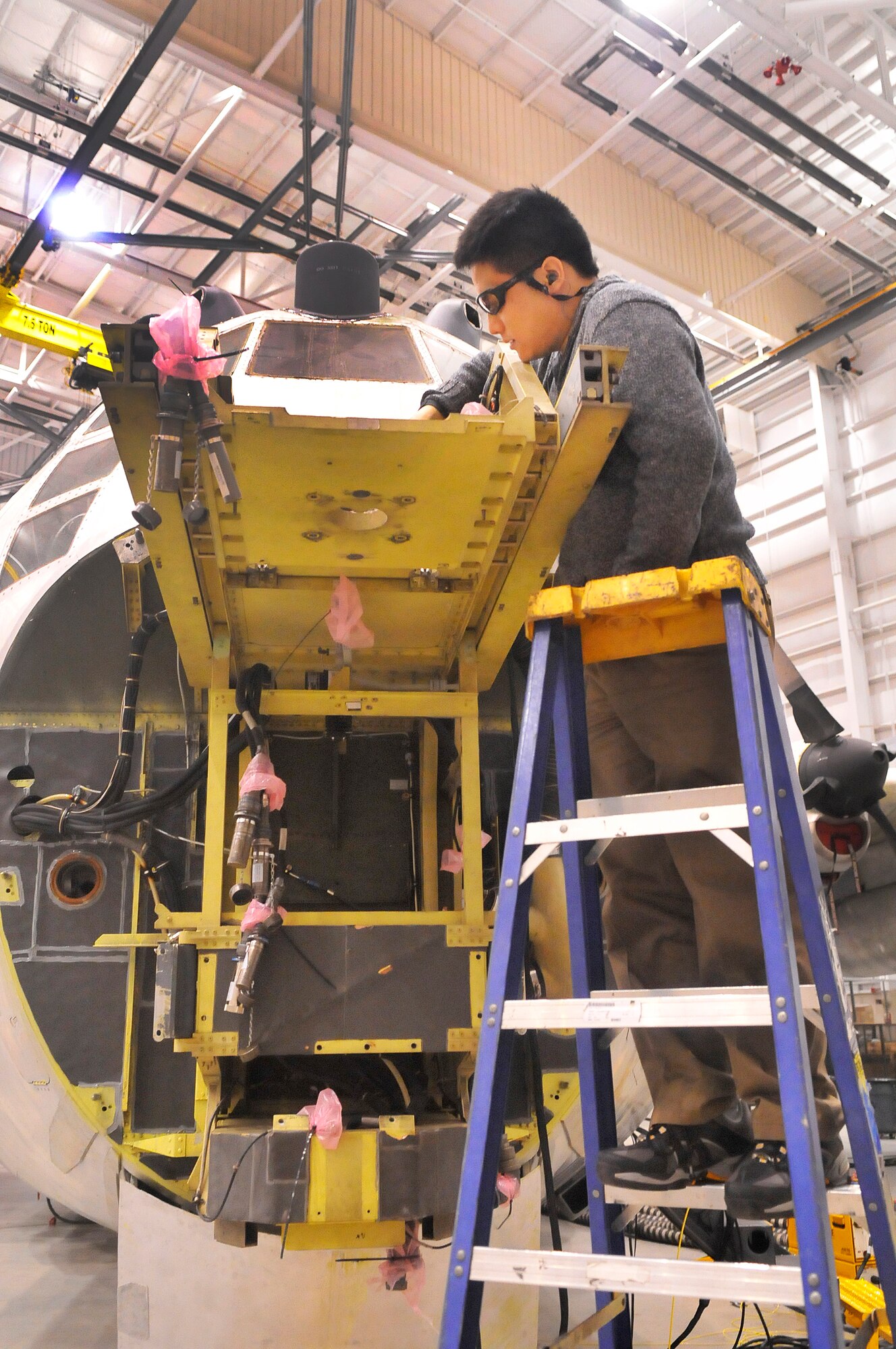 Jikai Feng, test developer, connects cables from the tester to a C-130. Robins Automatic Wire Test Set Team  has developed software to automatically test aircraft wiring systems in minutes, whereas manual testing takes weeks.  (U. S. Air Force photo/Sue Sapp)