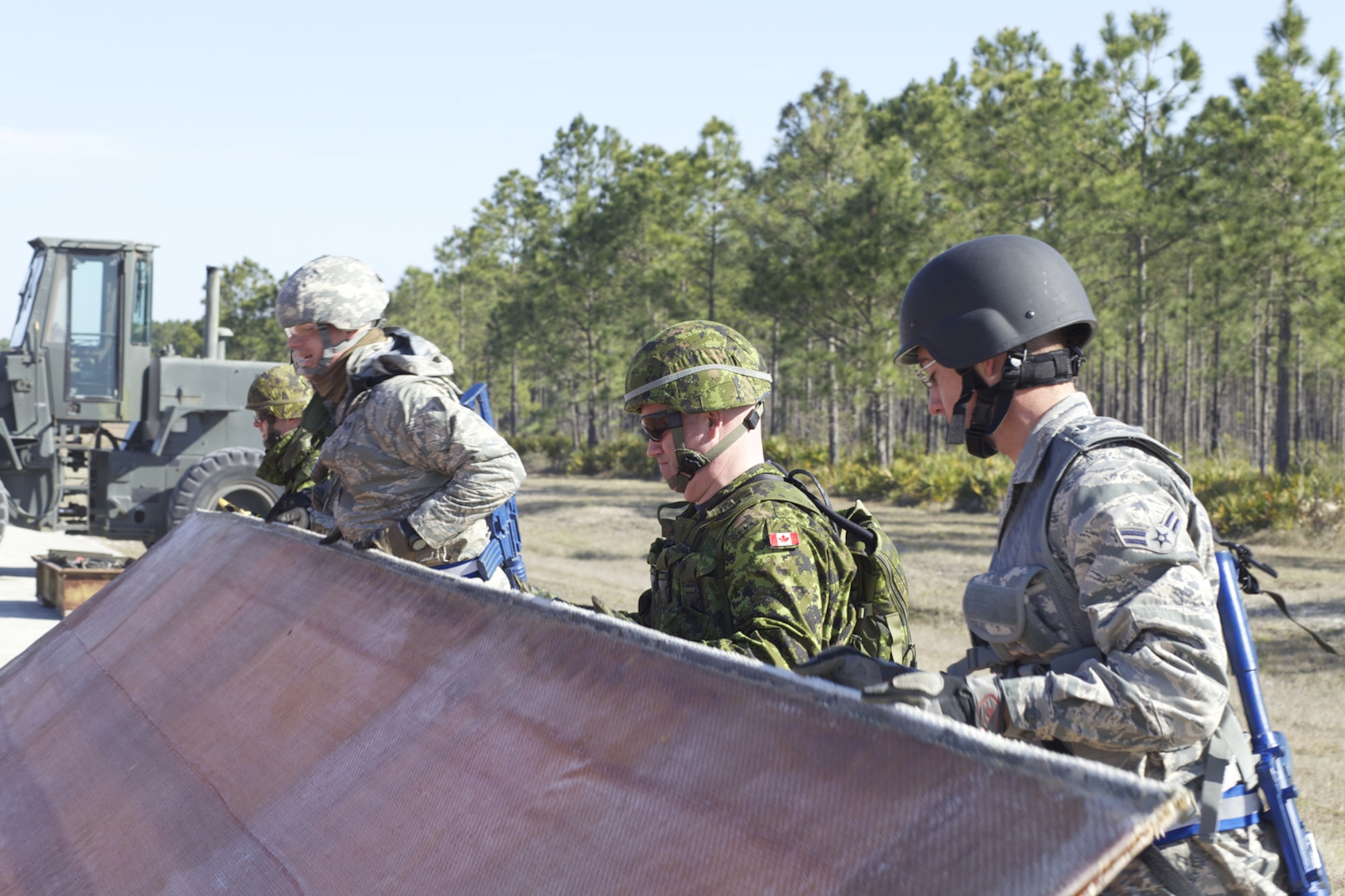 TYNDALL AIR FORCE BASE, Fla. -- Canadian and U.S. Airmen lift a section of folded fiberglass mat during an airfield damage repair exercise at the Silver Flag exercise site here March 7, 2013. Thirty-one Royal Canadian Air Force construction engineers joined their U.S. Air Force counterparts for the seven-day Silver Flag course which prepares civil engineers for deployment operations and gives them experience establishing and maintaining a base at a forward-deployed location. (U.S. Air Force photo/Eddie Green)