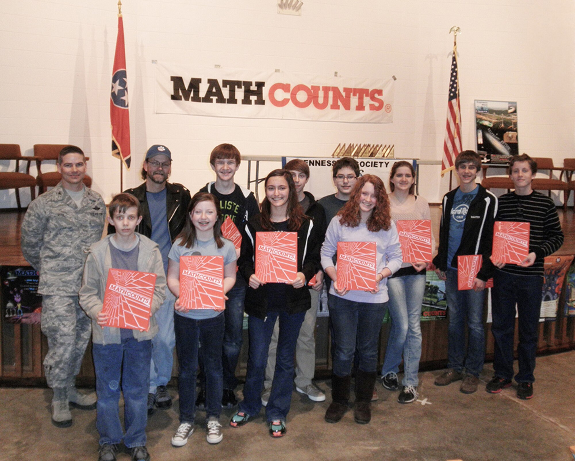 Arnold Engineering Development Complex Commander, Col. Raymond Toth stands with East Middle School students, front row, left to right: 7th graders Noah Weems, Abbie Daniel, Megan Schweitzer and Sarah Schweitzer.  Back row, left to right: Trent Stout, coach, 8th graders Andrew Mares and Caden Throneberry, Cooper Yoder, 7th grader, 8th graders Kathryn Brosemer, Spencer Baxter, and William Kuebitz. .(Photo provided)