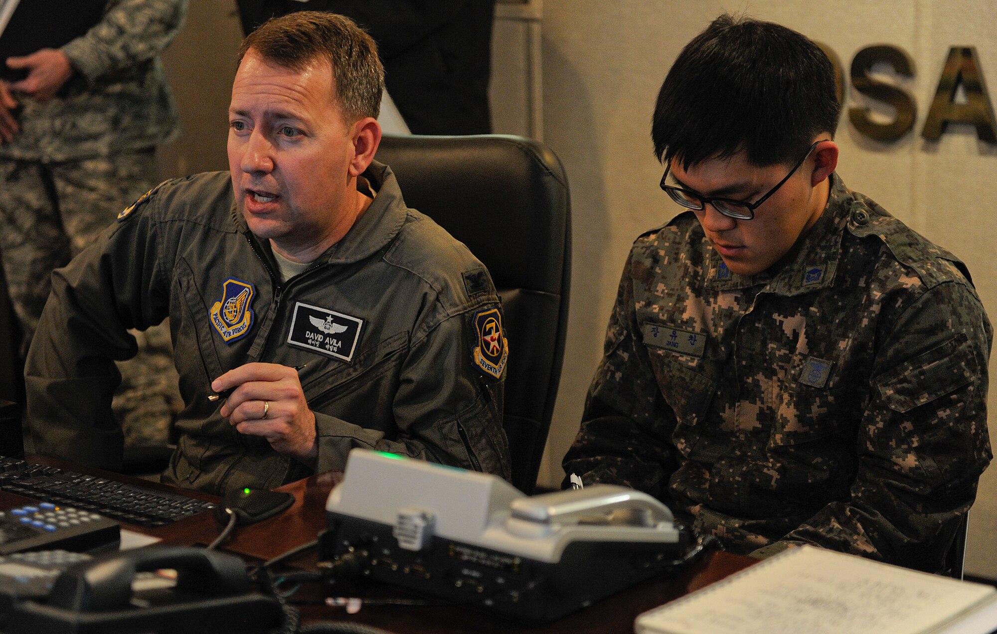 U.S. Air Force Col. David Avila, 7th Air Force operations and plans director, addresses members of the command staff brief while Republic of Korea 2nd Lt. Jang Yu-chan prepares to translate to Korean during Exercise Key Resolve on Osan Air Base, Republic of Korea, March 14, 2013. This exercise is executed to hone the skills necessary to defend the Republic of Korea by improving U.S. and ROK forces' operational capabilities and to increase Alliance readiness, protect the region and maintain stability on the Korean Peninsula. (U.S. Air Force photo/Staff Sgt. Zachary Wolf)
