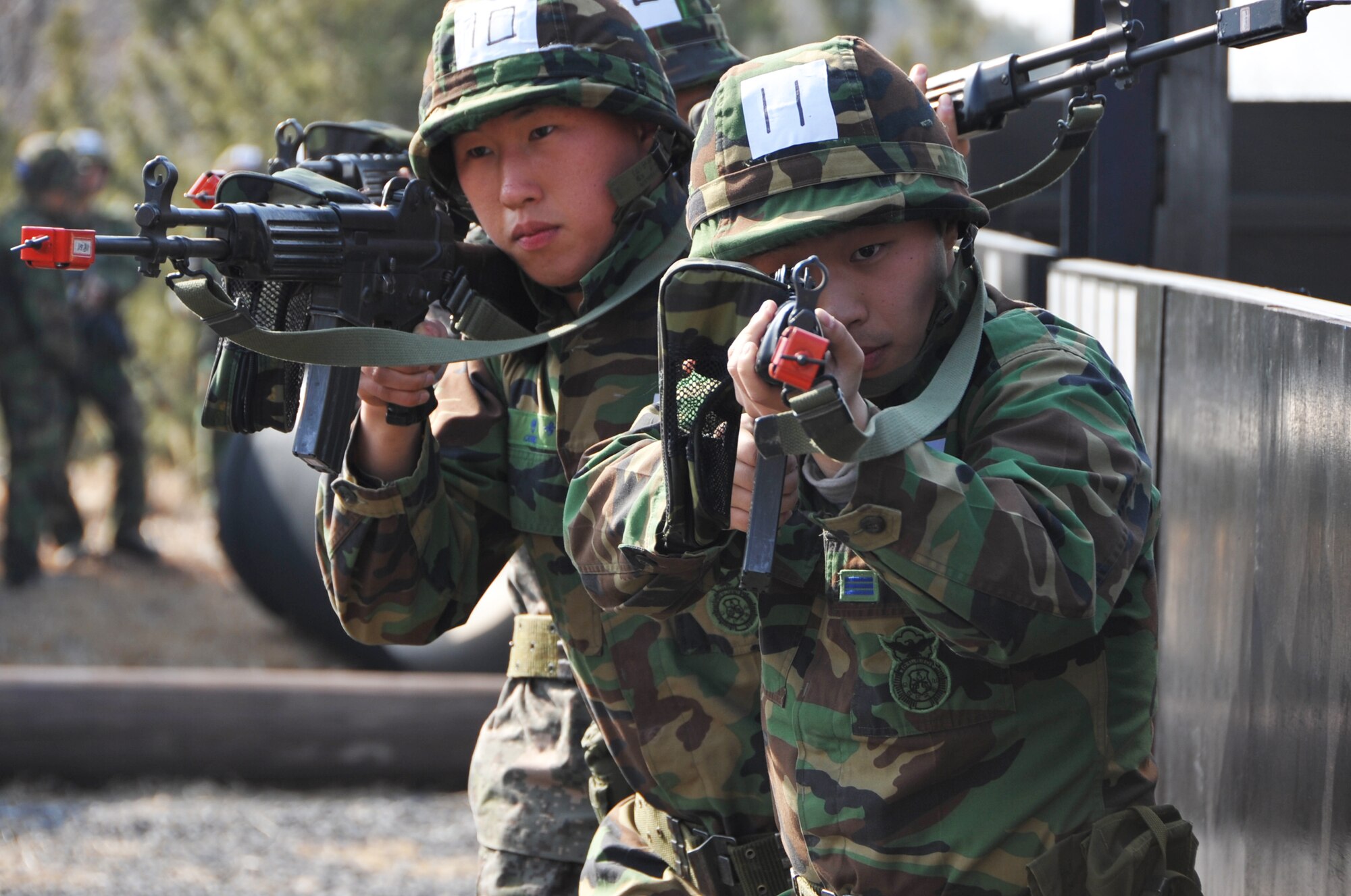 Republic of Korea Air Force air police members demonstrate tactical movement and clearing maneuvers during the Air Police Special Duty Team course at the JinJui Education and Training Command March 6, 2013.  The training courses, designed for special duty teams, included weapons firing in varied positions, obstacle courses with confidence courses to help members overcome fears such as heights, close combat, signaling and communication drills as well as building surveillance exercises. (U.S. Air Force photo/Senior Airman Kristina Overton)
