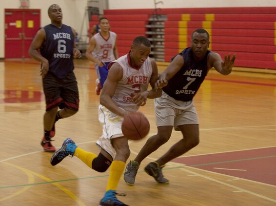 MARINE CORPS BASE HAWAII - Collin Foster, guard and coach for Combat Logistics Battalion 3, shoots the ball against a defender during an intramural basketball game against Marine Heavy Helicopter Squadron 463 at Semper Fit Center gym, March 13, 2013. Both teams played hard, but CLB-3 was able to snatch the victory with a score of 49-43, and secure a third-place spot going into playoffs. (U.S. Marine Corps photo by Lance Cpl. Jacob D. Barber)