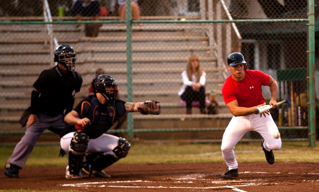 MARINE CORPS BASE HAWAII - Andrew Little, Marine Aviation Logistics Squadron 24 center outfield and head coach, bunts the ball during an intramural baseball game at Riseley Field, March 12. (U.S. Marine Corps photo by Cpl. James A. Sauter) 