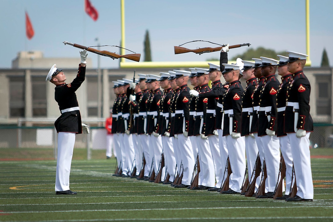 Cpl. Tyler Dutton, the Silent Drill Platoon Rifle Inspector, conducts a rifle inspection during the Battle Color Ceremony at the Paige Fieldhouse Football Field here March 15.