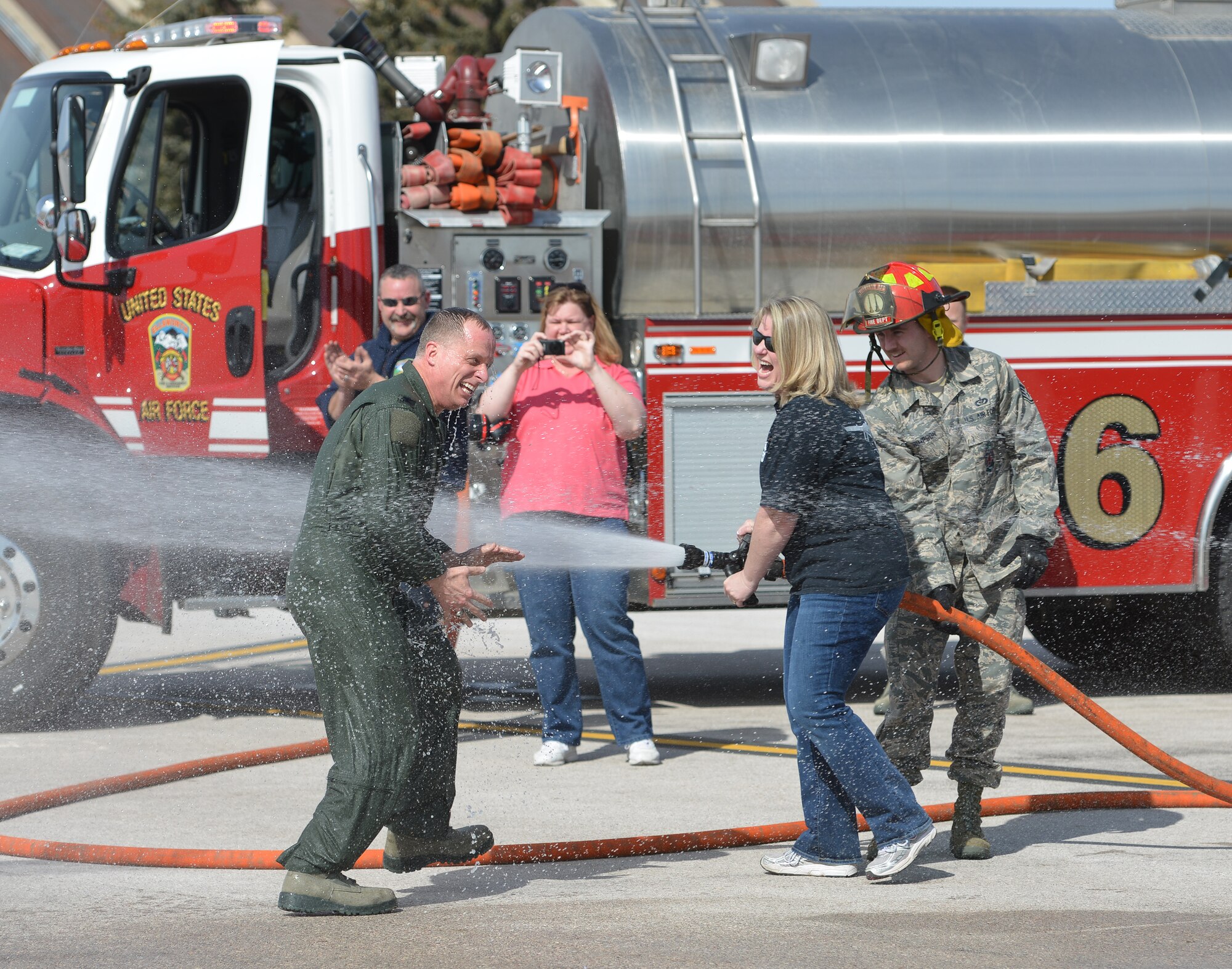 Stephanie Weatherington sprays her husband, Col. Mark Weatherington, 28th Bomb Wing commander, after his end of tour flight at Ellsworth Air Force Base, S.D., March 14, 2013. A change of command ceremony will be held April 5, to welcome Ellsworth’s new wing commander, Col. Kevin Kennedy. (U.S. Air Force photo by Master Sgt. John Barton/Released)