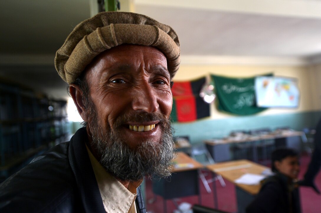 A local Afghan man watches as members of the 755th Expeditionary Security Forces Squadron Reaper Team 1 patrol a school near Bagram Airfield, Afghanistan, March 11, 2013. The 755th ESFS Reaper teams operate missions “outside the wire” providing security during key leader engagements and meetings with the local community. (U.S. Air Force photo/Senior Airman Chris Willis)