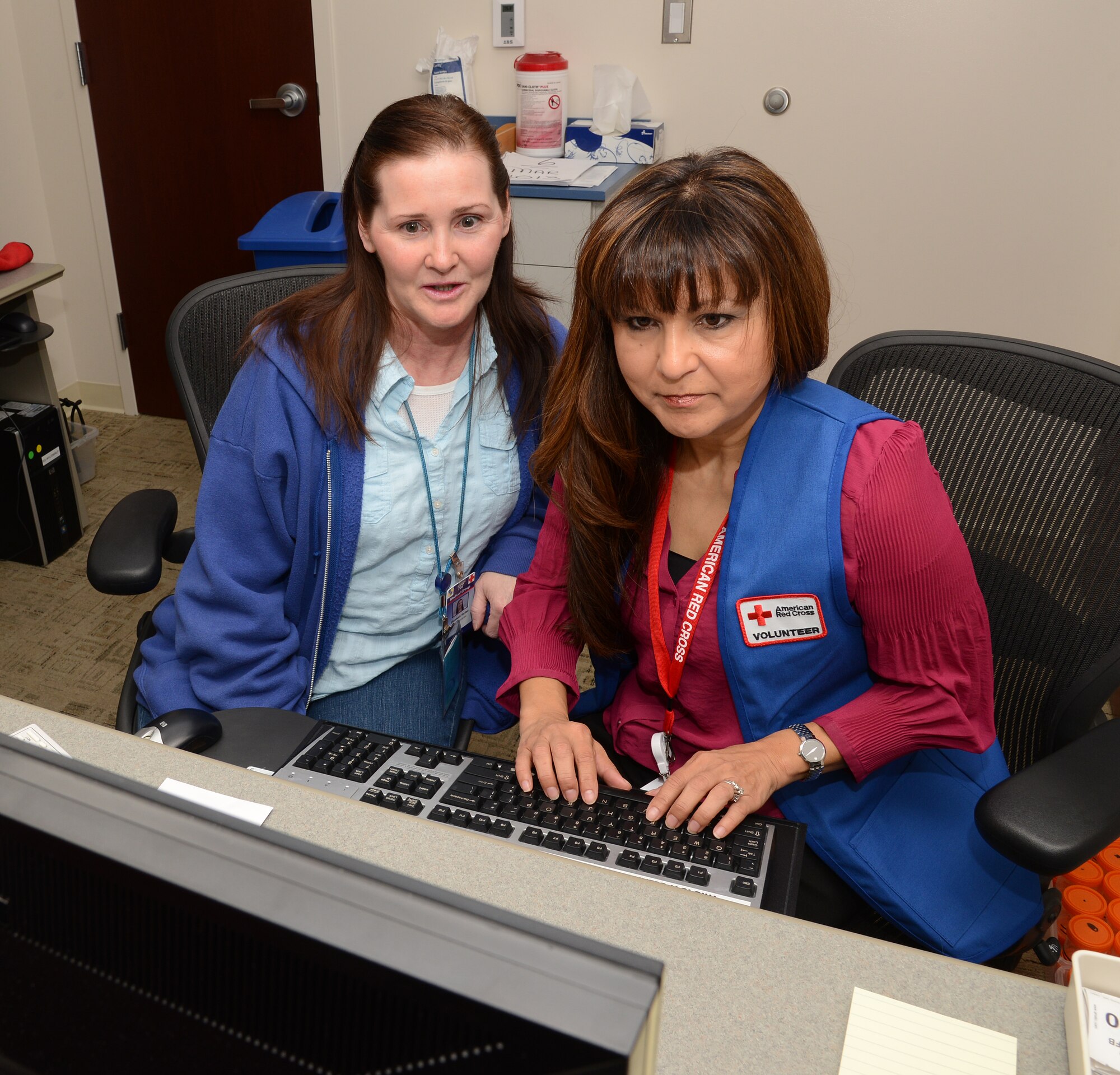 Elizabeth StClair, a Health Technician with the 72nd Medical Support Squadron, teaches Red Cross Volunteer Sofia Griffith how to enter patient information into the Composite Health Care System at the Laboratory front desk. Ms. Griffith volunteers five days a week in the Laboratory and Medical Records departments in the Med Group. (Air Force photo by Kelly White)