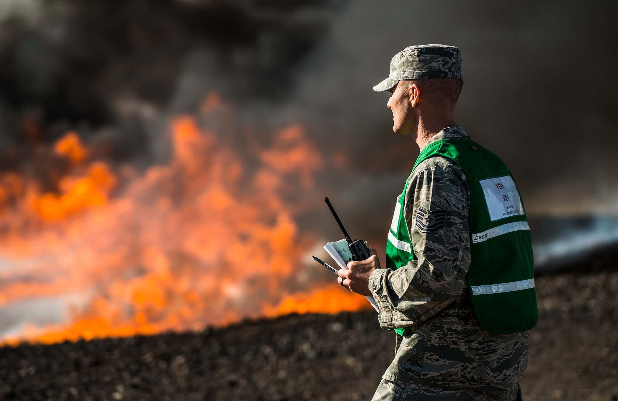 MOUNTAIN HOME AIR FORCE BASE, Idaho -- U.S. Air Force Tech. Sgt. Michael Champion, 366th Civil Engineer Squadron exercise evaluation team member, monitors a live fire training exercise during a base-wide operational readiness exercise March 4, 2013, at Mountain Home Air Force Base, Idaho. Champion watches the team closely and provides feedback to the firefighters and wing leadership on how they can improve. (U.S. Air Force photo/Tech. Sgt. Samuel Morse)